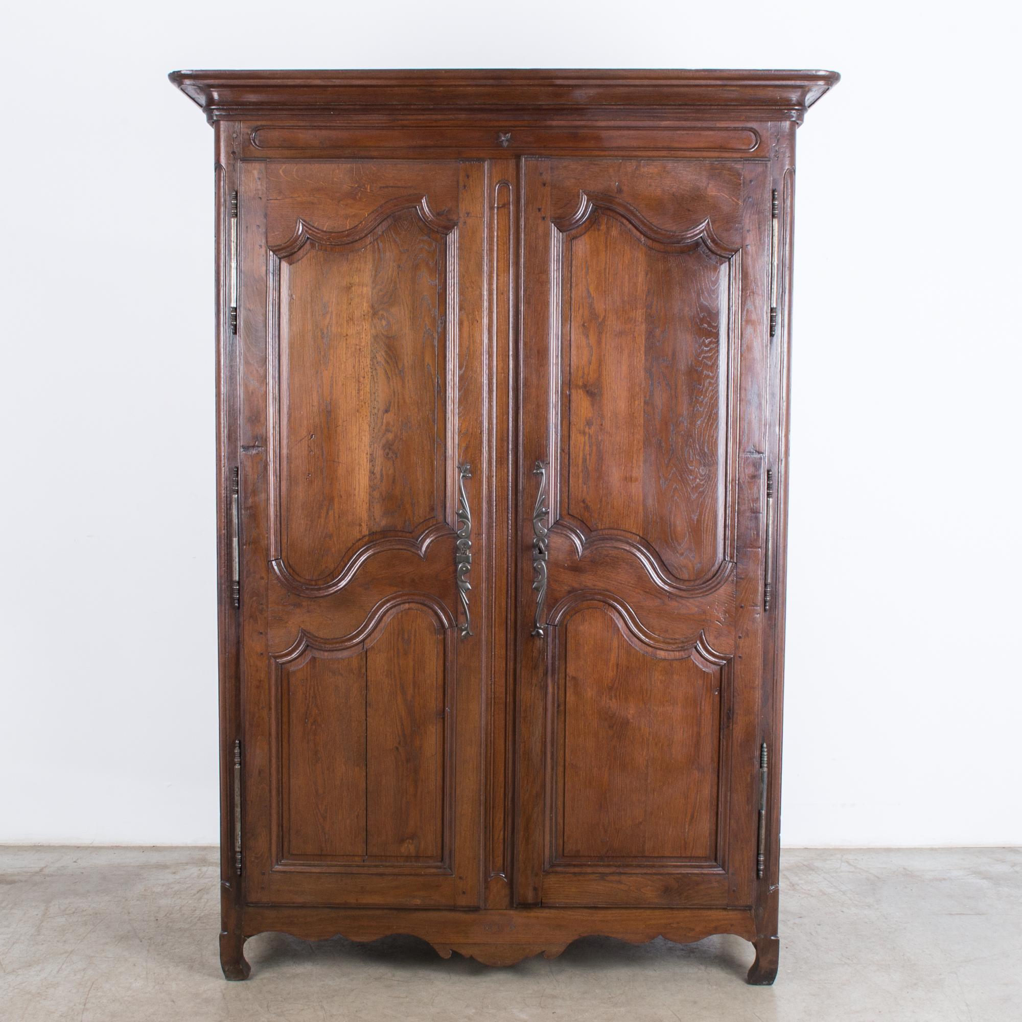 This rococo armoire was made in France at the turn of the century. Full featured French provincial Classic, rich varnish, double doors with S-shaped curves, practical interior shelves, scalloped apron and charming pigeon-toed front feet, engraved