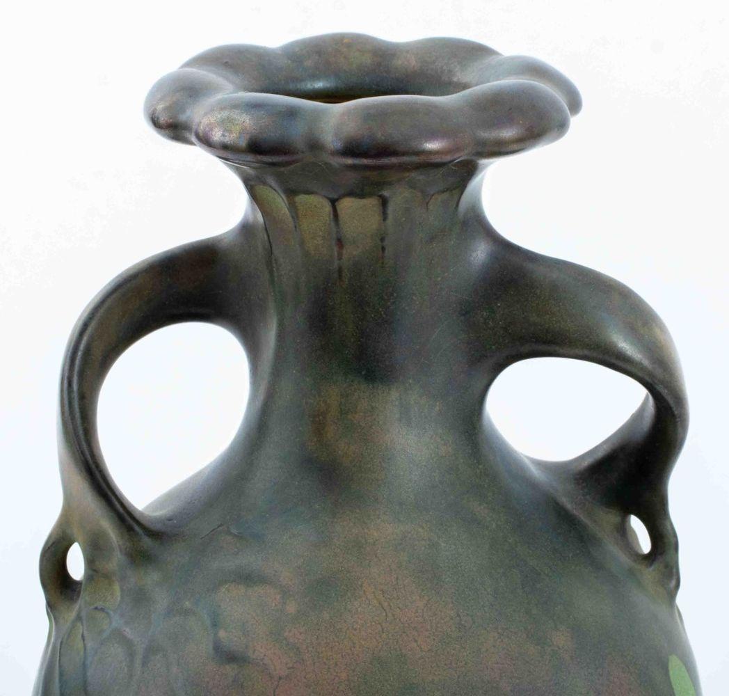 Vase à taille cylindrique en poterie Art nouveau de Teplitz, vers 1900, à lèvre floriforme et anses appliquées en forme de vigne sinueuse, émaillé en or irisé tacheté et vert réservé sur un fond de couleur terre pâle, 