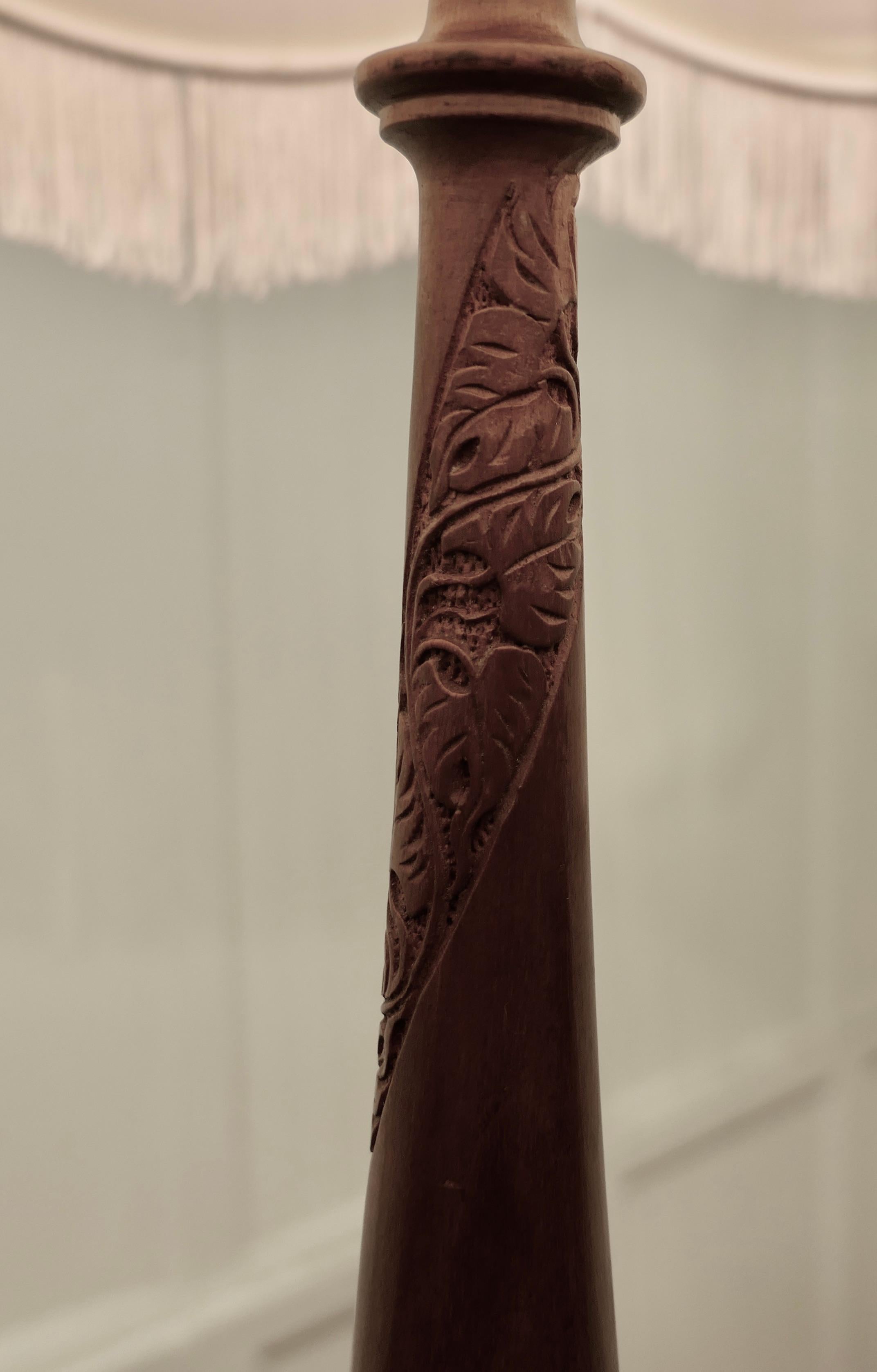 Turned and carved teak floor standing or standard lamp

This is an attractive heavy quality piece in polished teak, the lamp stands on a turned wooden base, the upright is also turned and it has a carved decoration twisting its way up 
The lamp