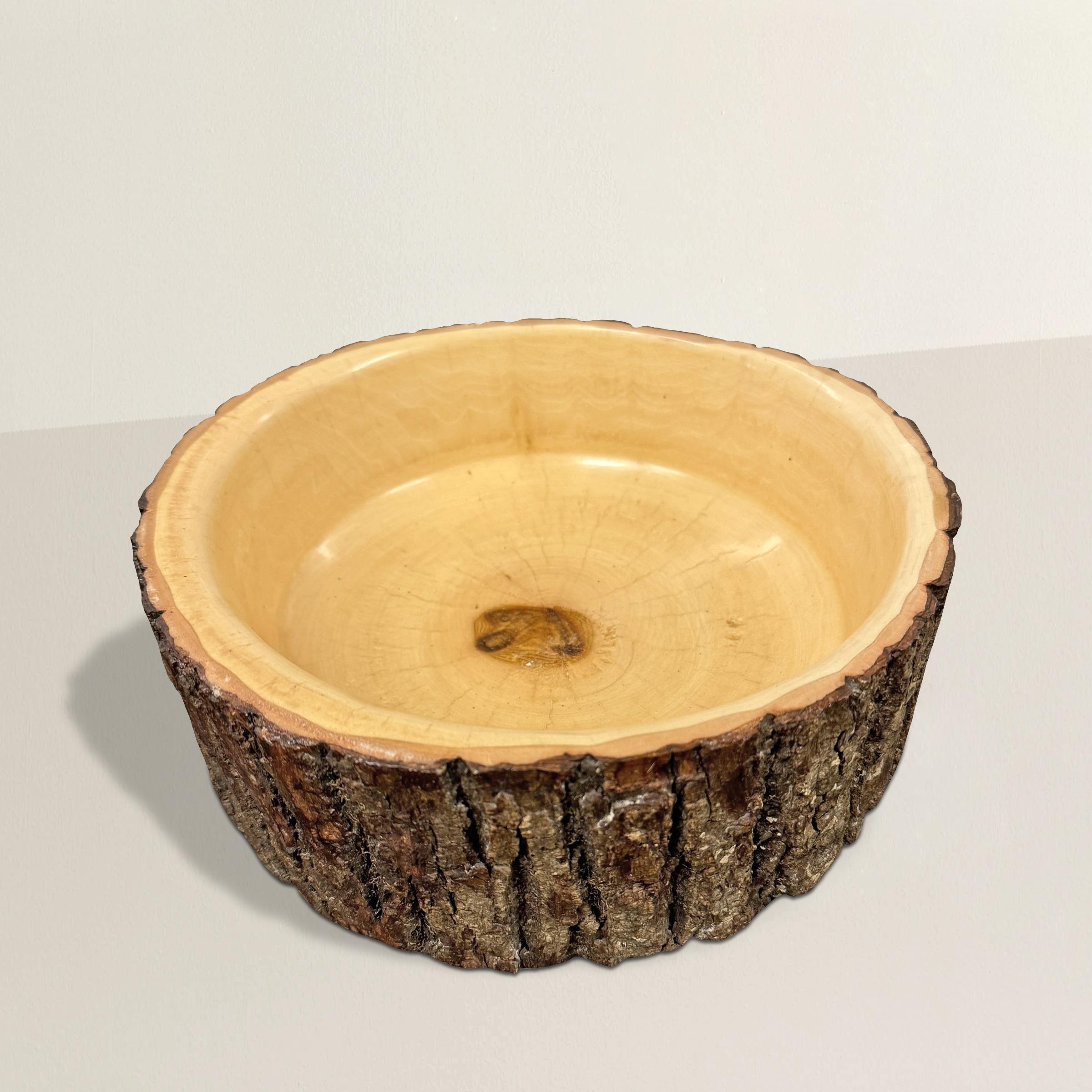 This hand-turned ash wood bowl, found in Wisconsin’s Door County, is a celebration of natural form and craftsmanship. Carefully shaped by a local artisan, it retains its organic edge with a band of bark left intact—offering a raw, rustic