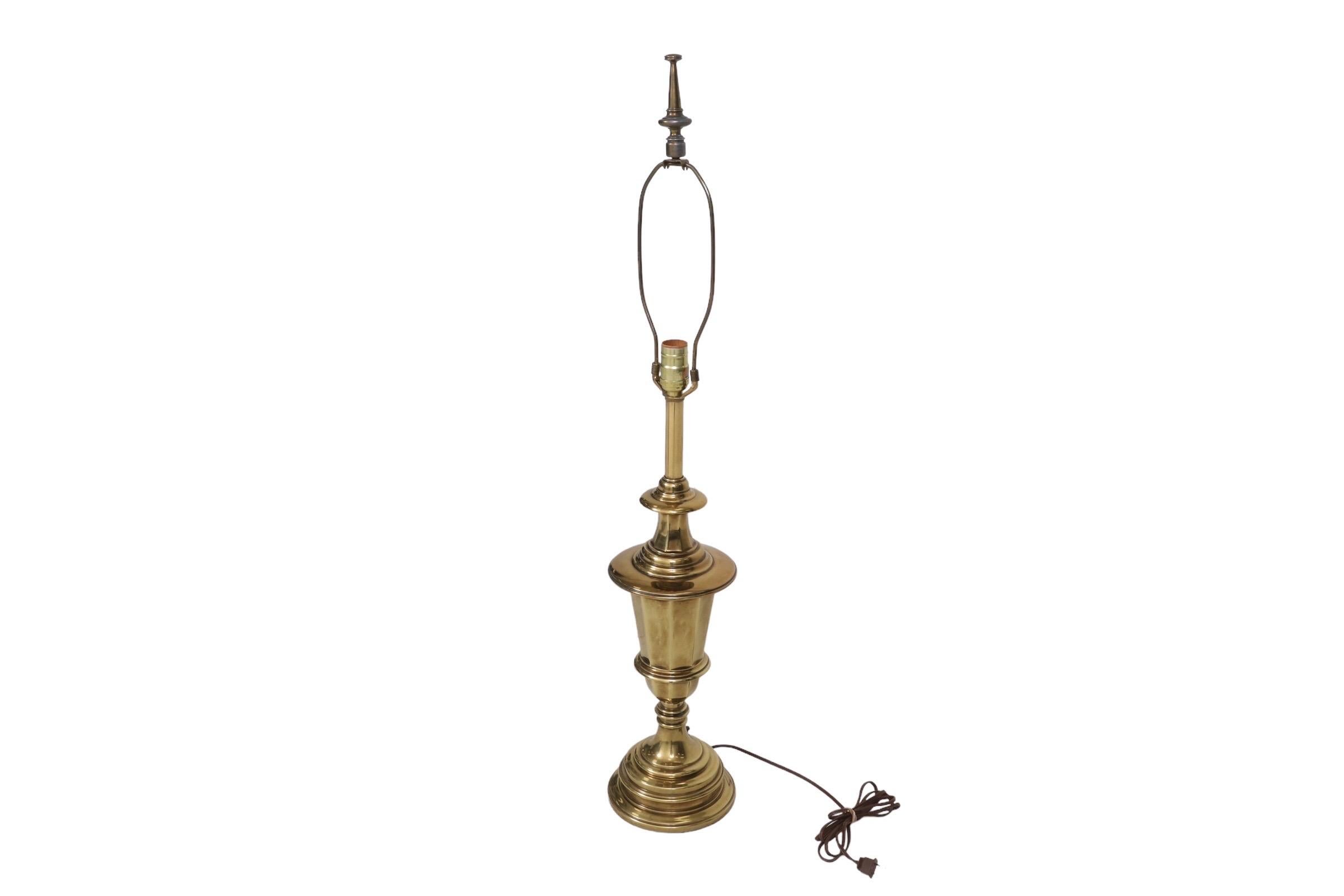 A turned brass table lamp made by Stiffel. A turned central column, above an octagonal angled vase, is mirrored with a round turned base. Topping the harp is a matching turned brass finial. The Stiffel maker's label can be seen on the socket. Wired
