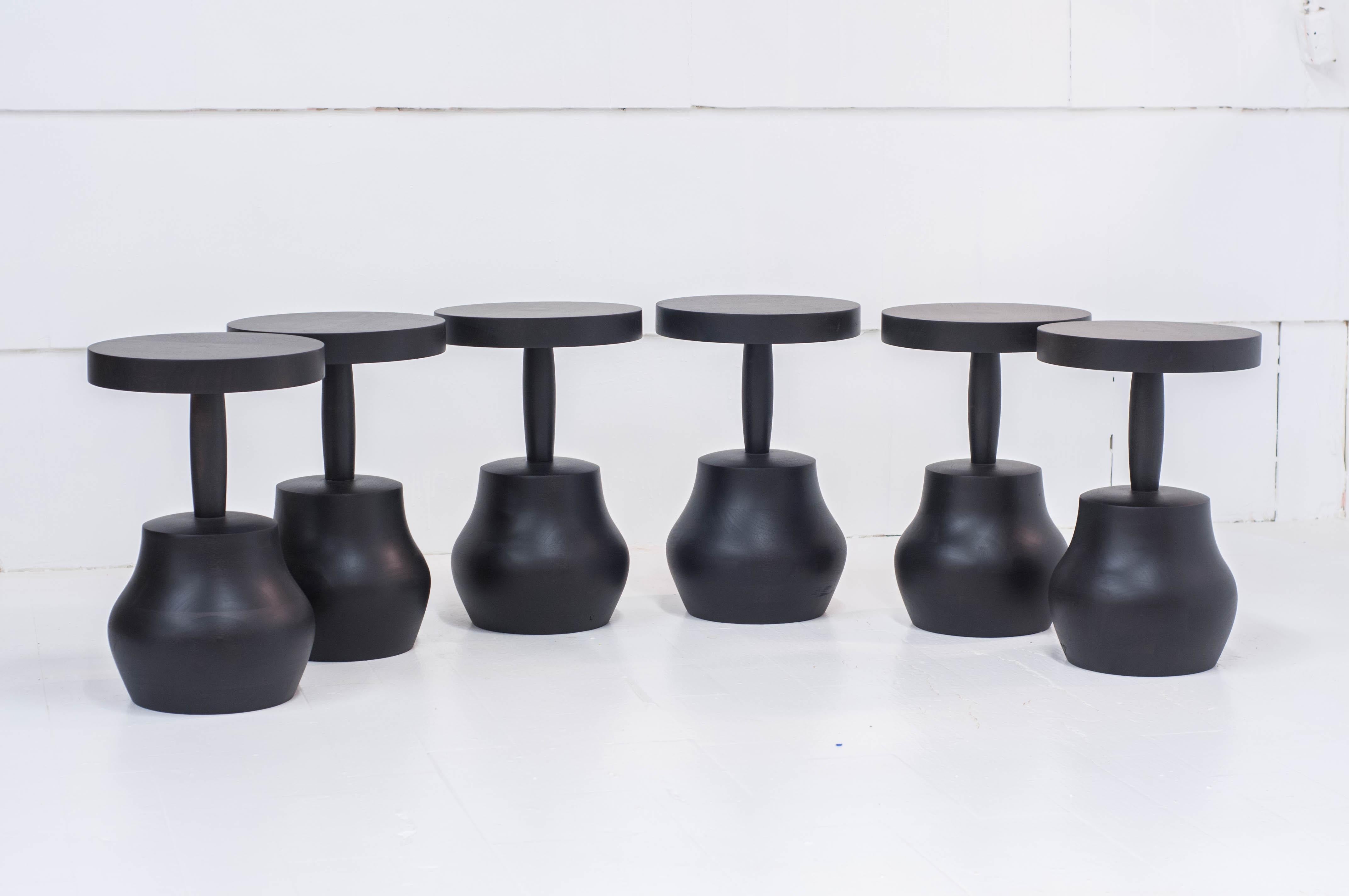 Curvaceous bell shaped side tables in hand carved solid wood.