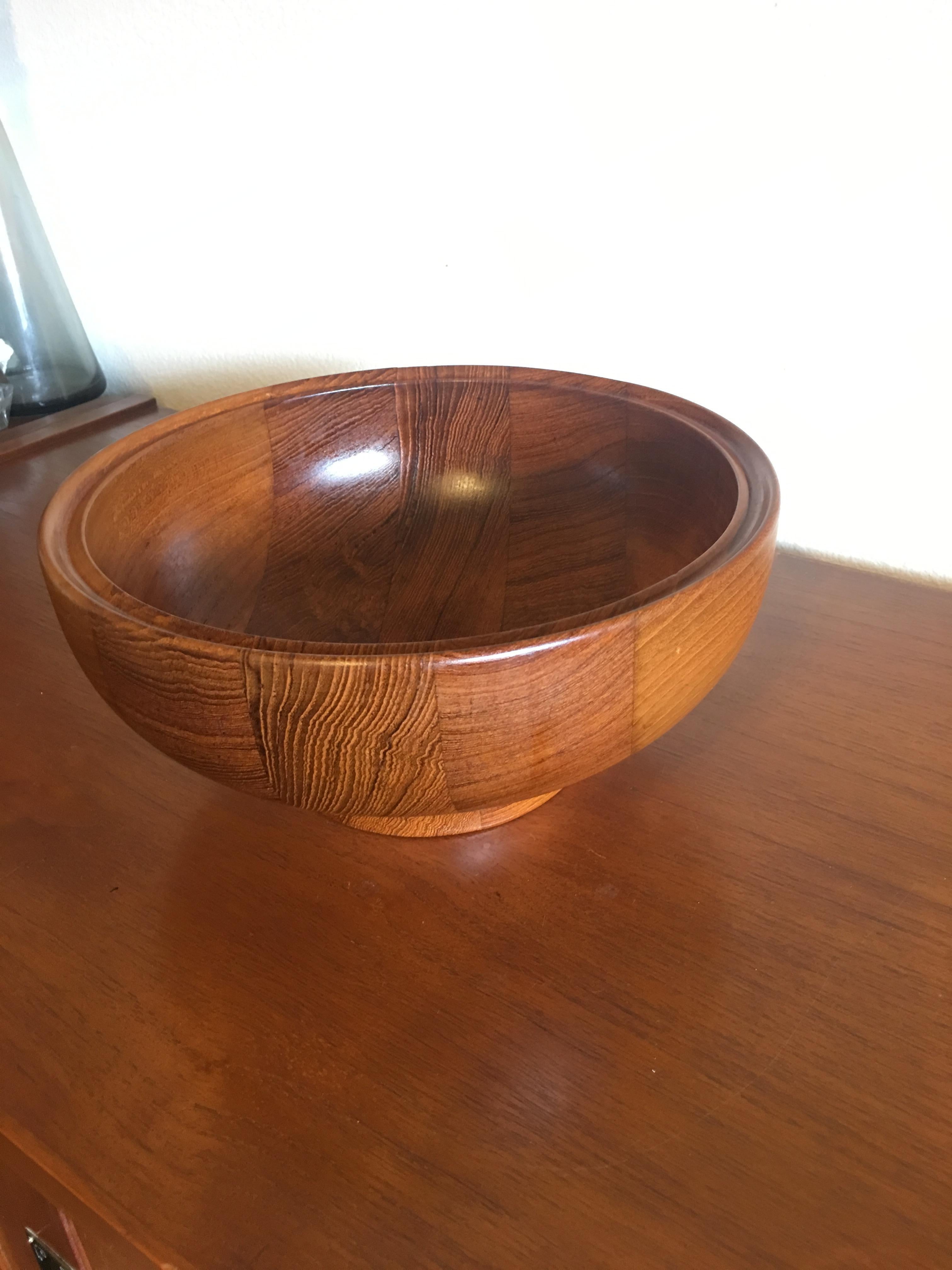 This teak bowl designed by Henning Koppel for Georg Jensen is a beautiful and functional piece that will add a touch of elegance to your home decor. Made from high-quality teak wood, this bowl has a smooth and polished finish that highlights the
