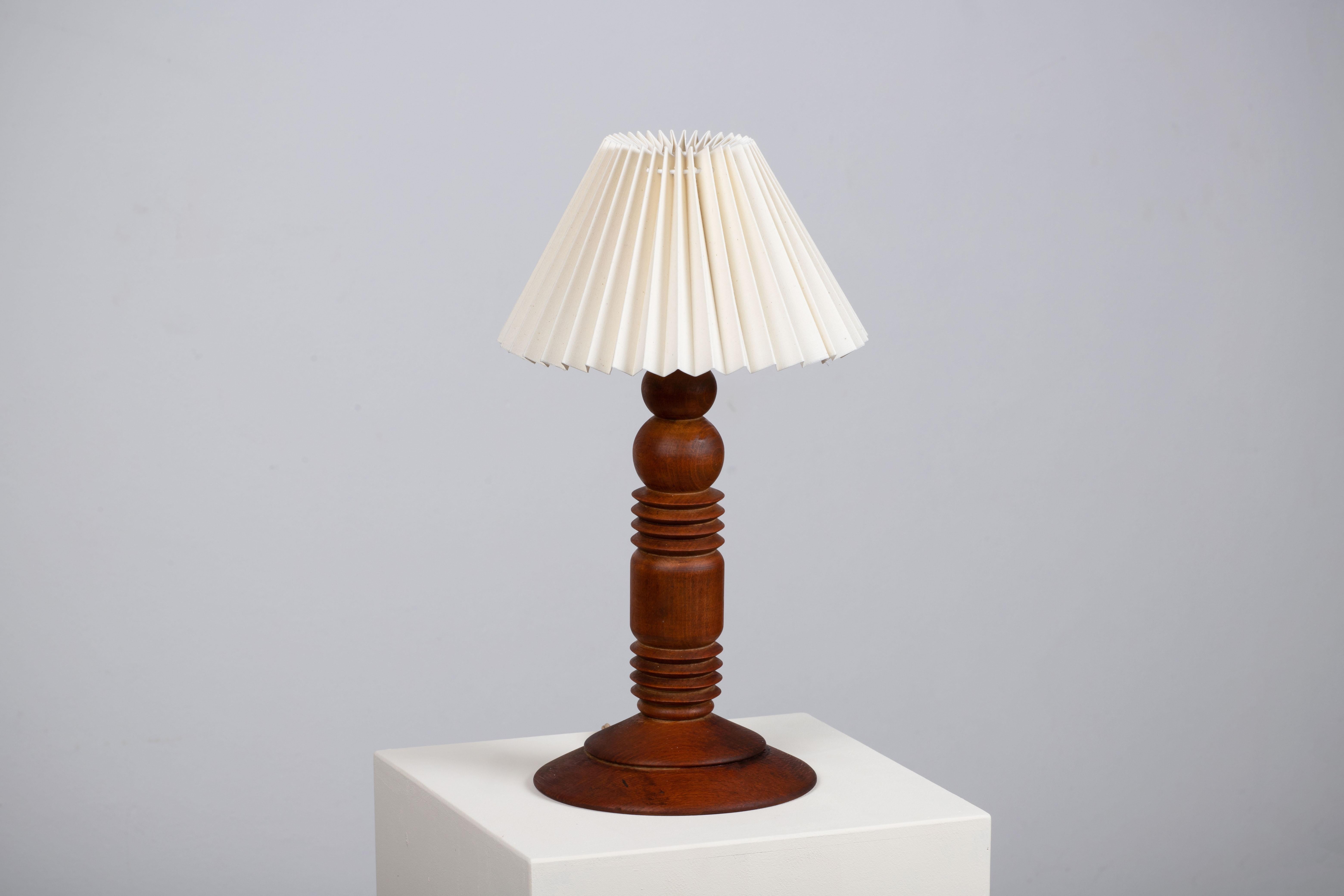 A Mid-century table lamp. In solid Teak, Denmark, 1960. 

Elegant teak lamps, pleated lampshade. It is in good general condition and works perfectly. The diffused light is very pleasant and the lamp offers a warm atmosphere.

Height without