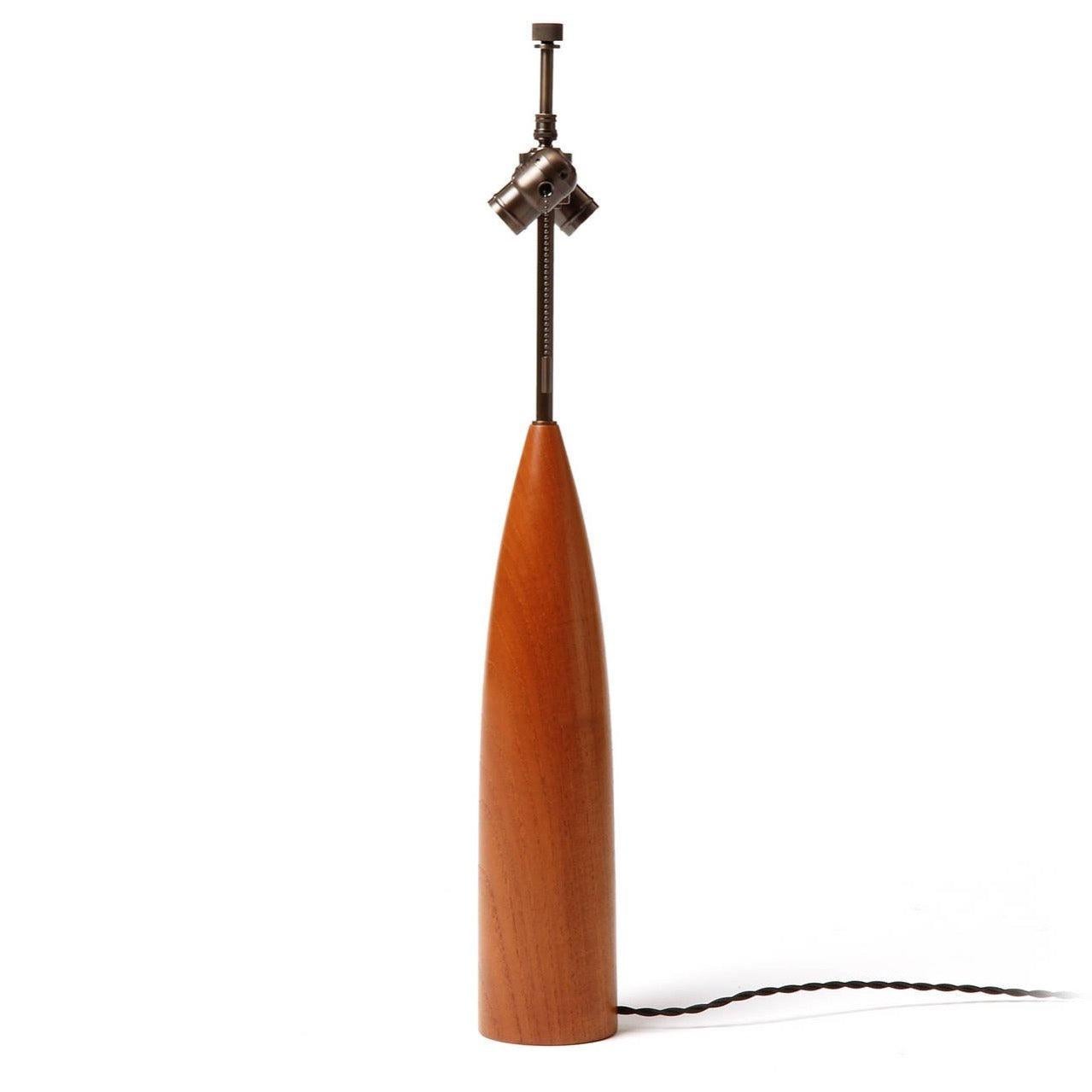 A sculptural and elegant table lamp, turned from a solid piece of teak.