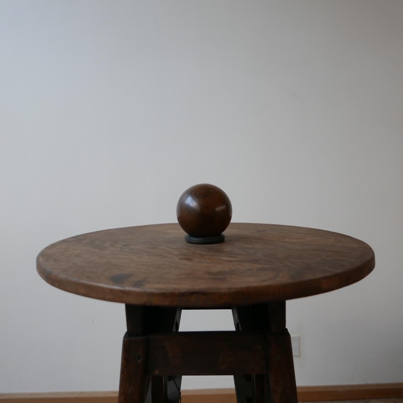 A large turned ball.

Very tactile, solid walnut ball.

Early 20th century, Holland.

Currently residing on a vintage toy wheel which is an odd pairing but means the ball can be turned without rolling away.

Full of character. Perfect