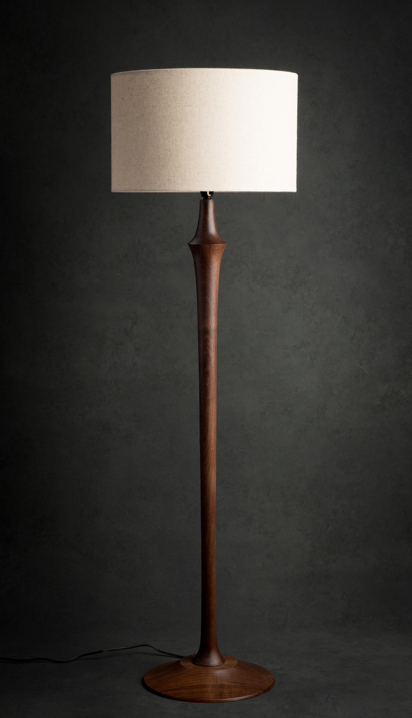 The Guthrie floor lamp is hand-turned on the lathe and can be made out of walnut, cherry, or ash. It features a brass socket, ferrule, and finial and a brown cord. Fabric cords are an option. 

The lamp (not including the shade) is 43