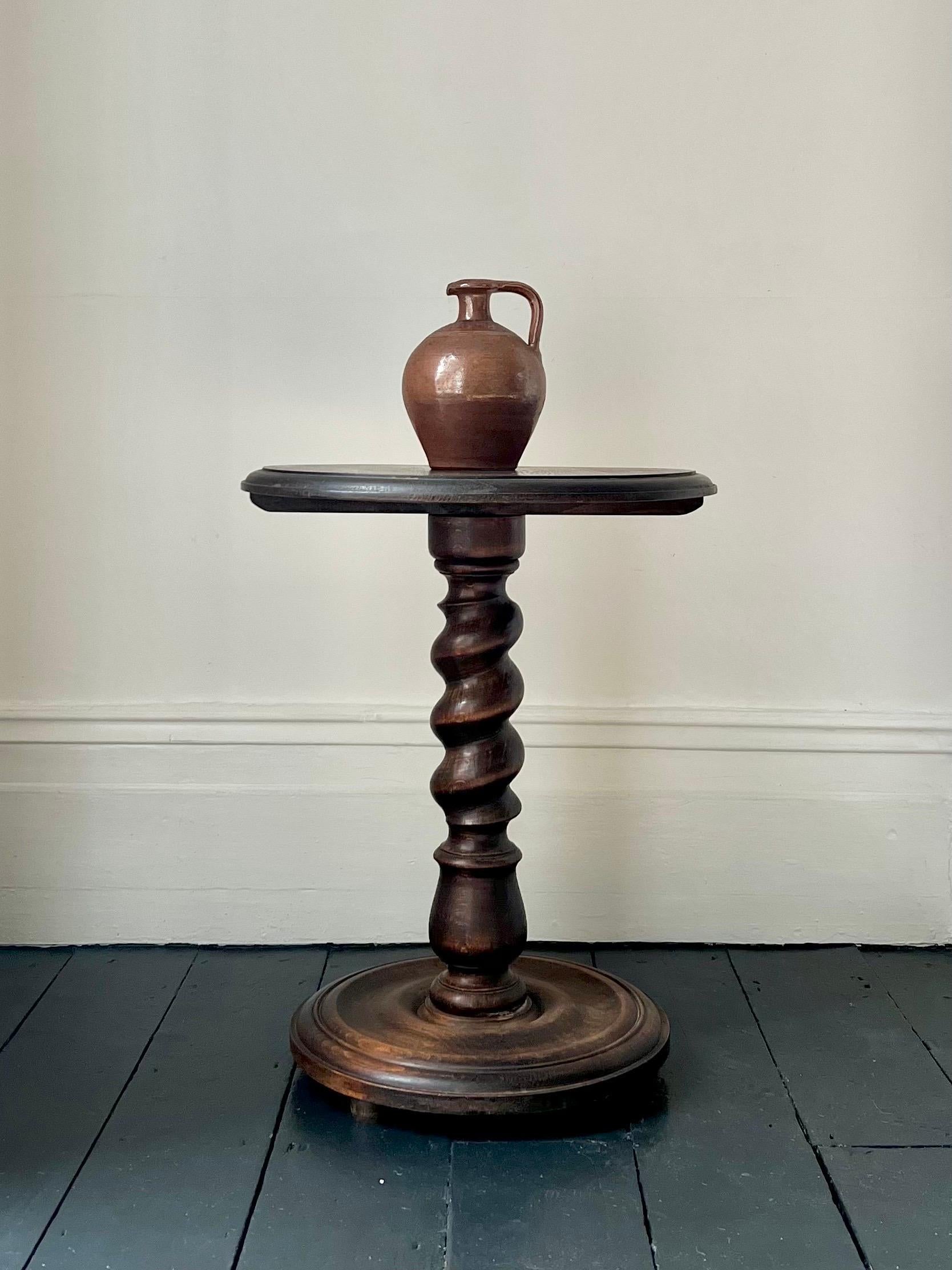 A turned wood side table with barley twist stem and heavy base. First half twentieth century, perhaps English or French. Reminiscent of the work of Charles Dudouyt (1885-1946).

The wood - possibly oak - has been stained with a mid-to-dark finish.