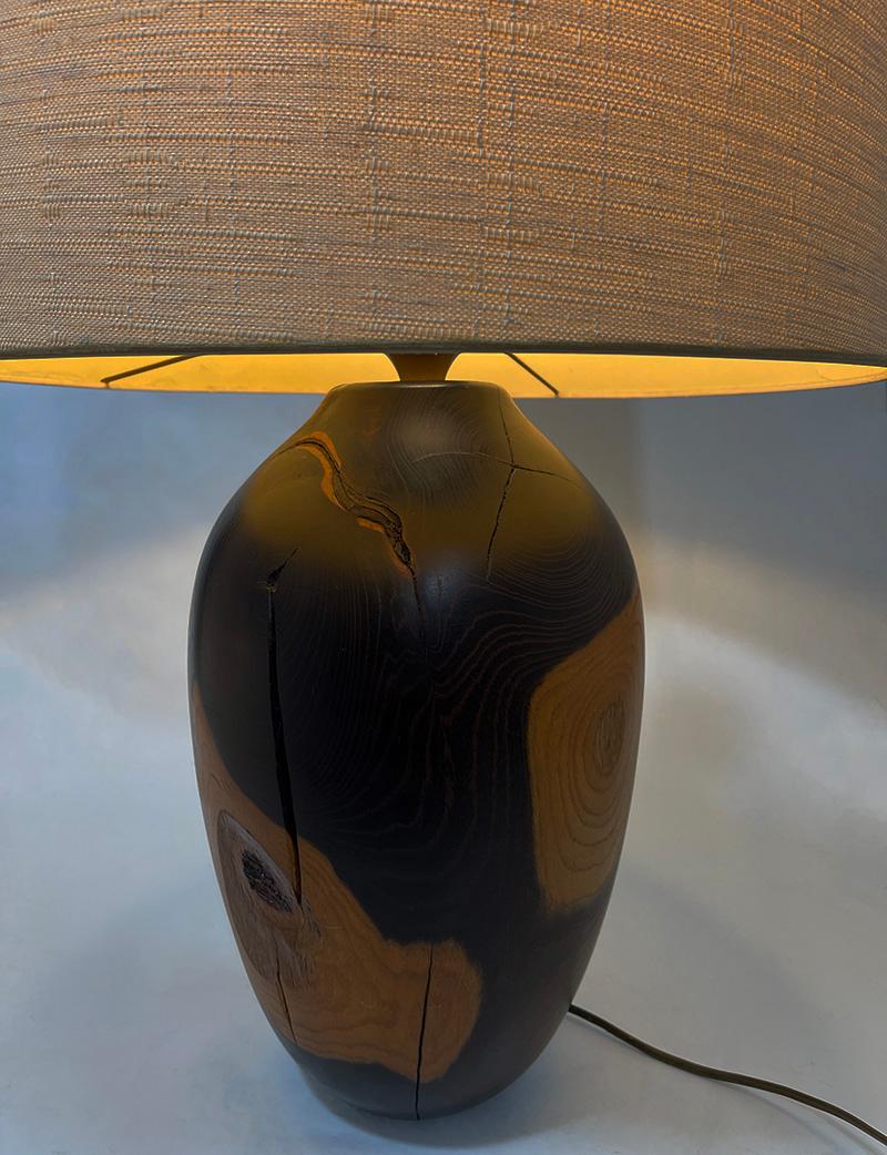 Turned wood table lamp, 20th Century

A beautiful wooden table lamp with a beautiful patina. There is a signature underneath, but not recognizable. The type of wood Goncalo alves, tigerwood is brown to orange colored wood and the lamp weighs