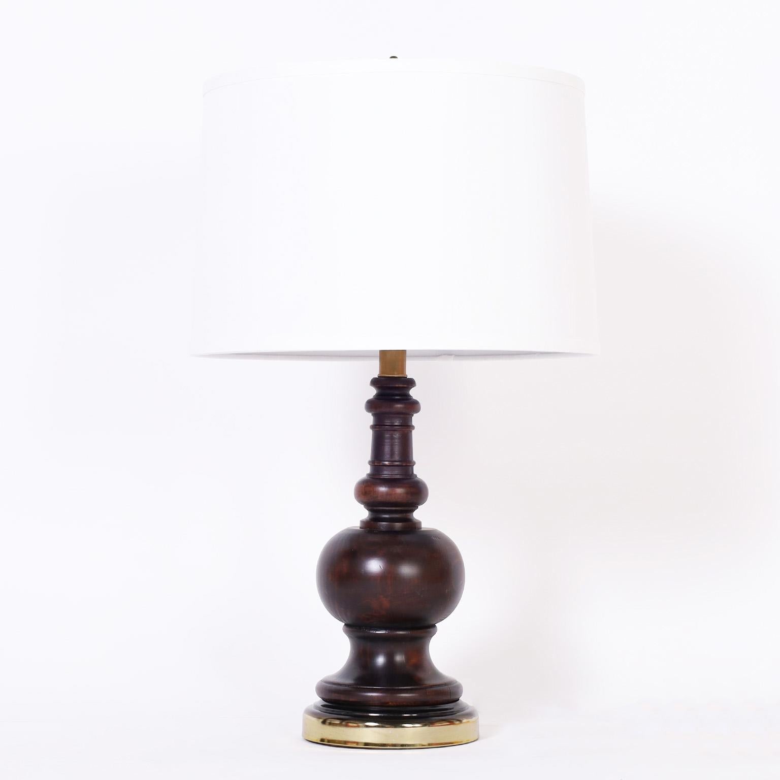 Mid century British colonial style table lamps crafted in turned wood with classic form and a mahogany finish. Two pair available.
