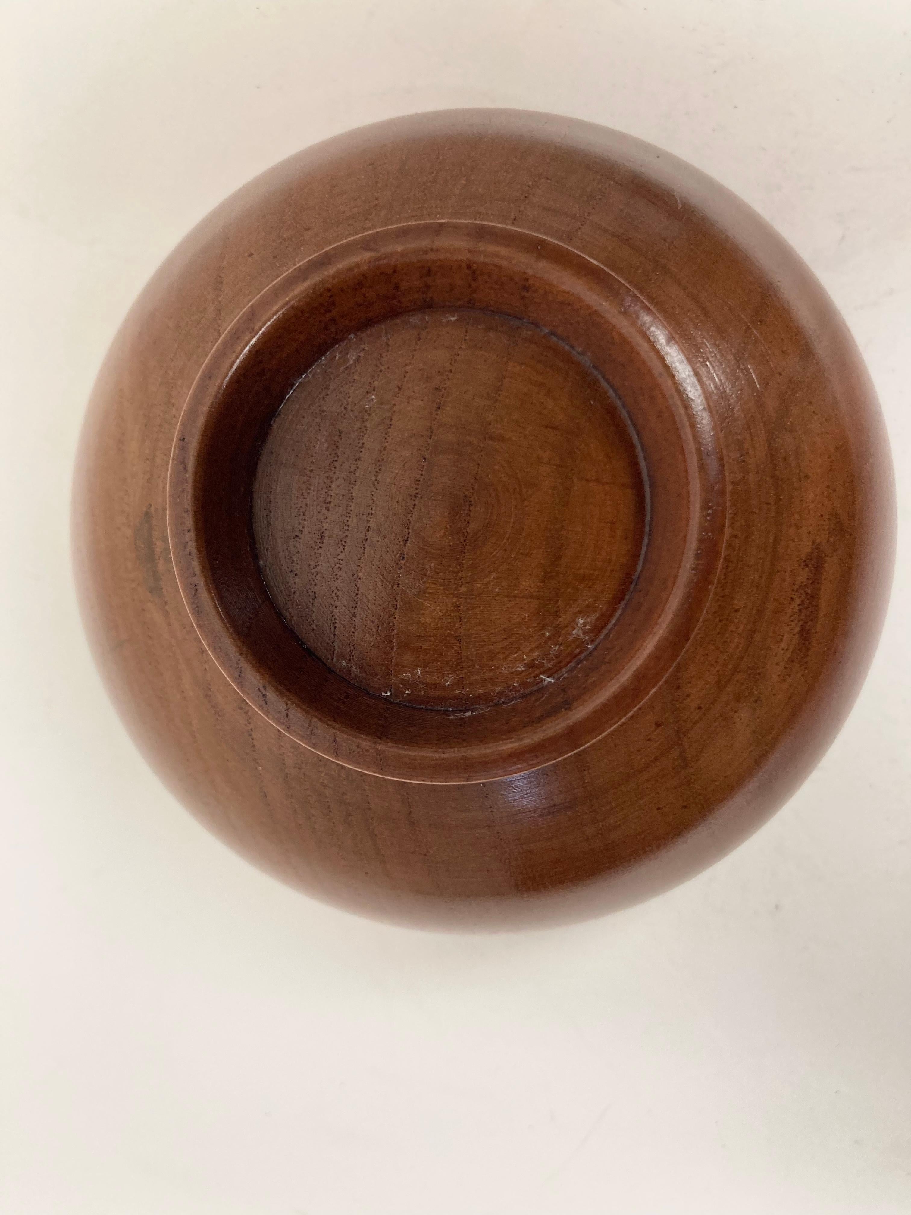A very well turned diminutive Wood Bowl in Japanese Tea Bowl form. With delicate thin walls and supported by a ring base. Made from hardwood, likely Ash, the Bowl has subtle graining and a fine Amber tone with Lacquer finish and is in its shape and