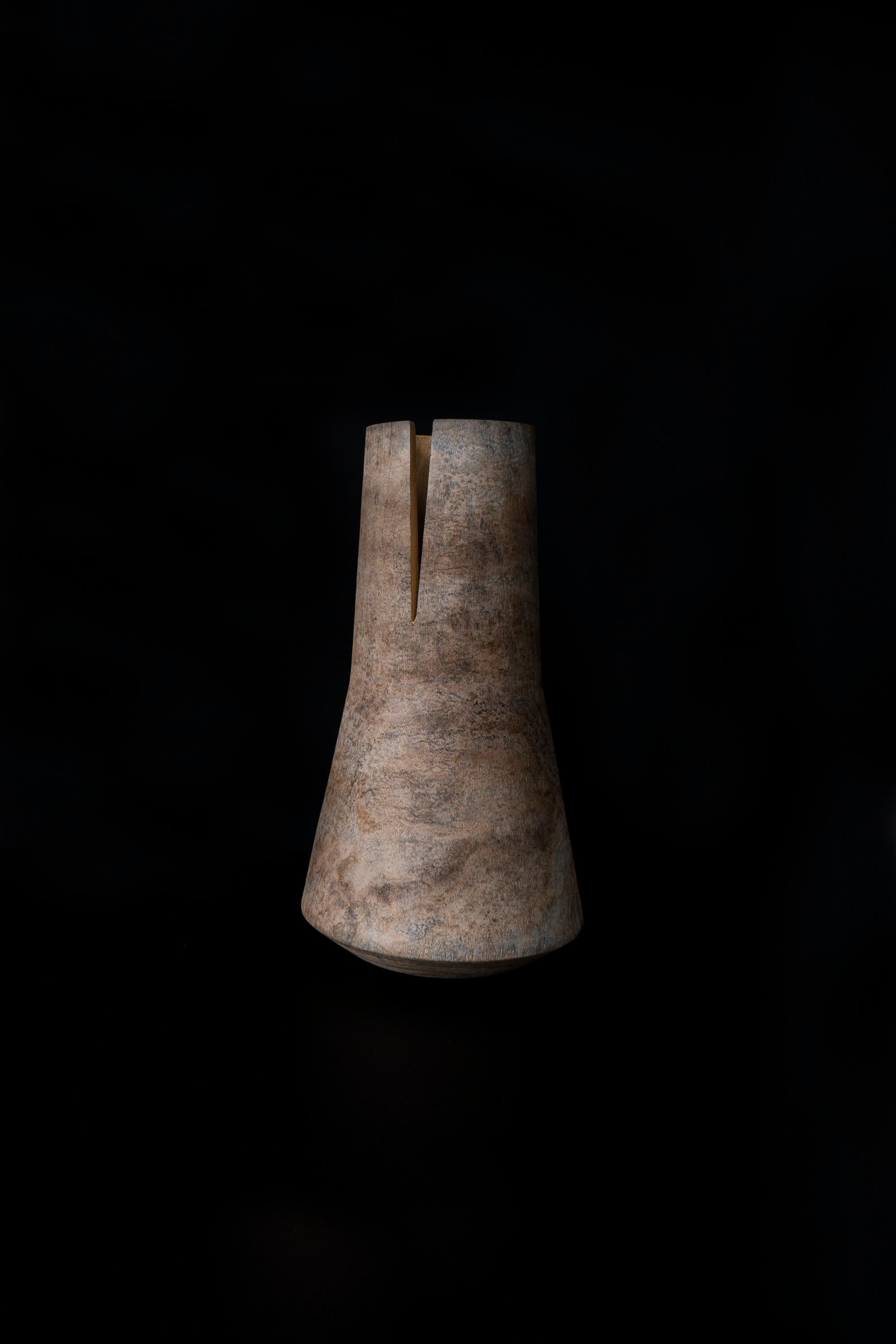 Tomahawk est un vase essentiel mais beau, réalisé en bois de mûrier teinté avec une finition à base d'oxyde de titane. 
La forme simple est fendue par un coup de hache qui caractérise l'image. Ce vase se décline en trois formes différentes, conçues