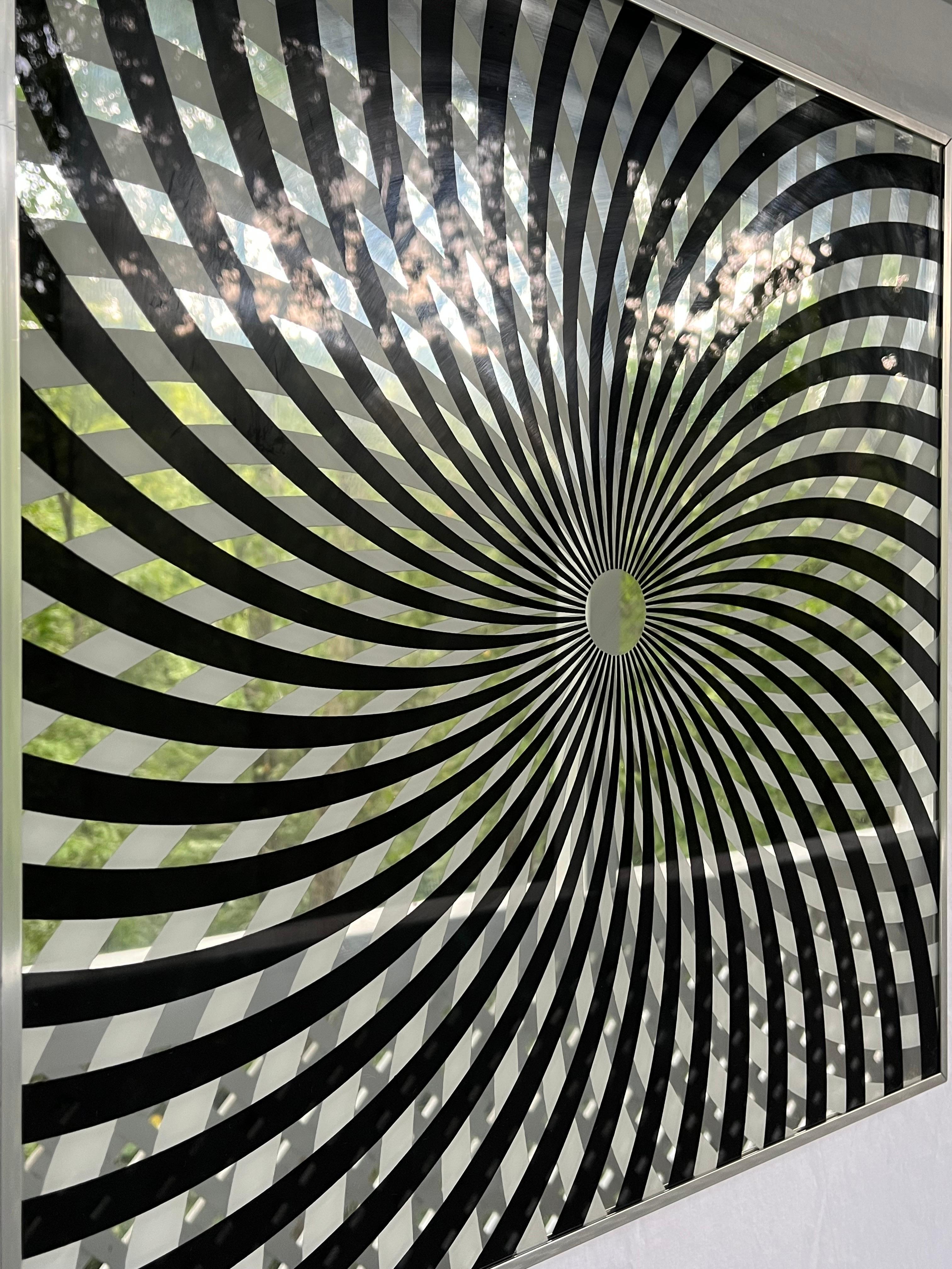 A vintage 1970's op art style square mirror presented in an aluminum frame by the Chicago based Turner Manufacturing Company. The black and white graphic, pop art style pinwheel or kaleidoscope design epitomizes all that was in the 1970's. This