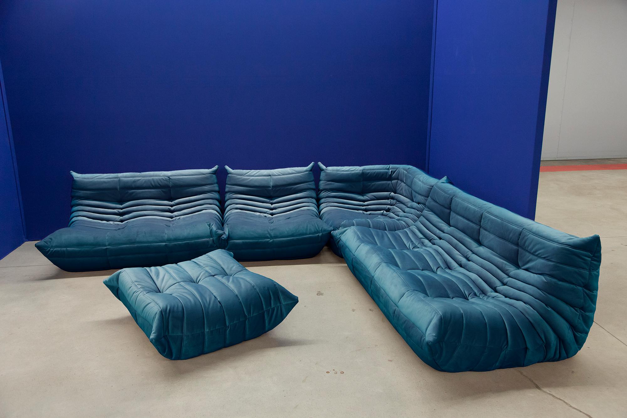 This Togo living room set was designed by Michel Ducaroy in 1973 and was manufactured by Ligne Roset in France. Each piece has the original Ligne Roset logo and genuine bottom. It has been reupholstered in genuine high quality turquoise/blue velvet