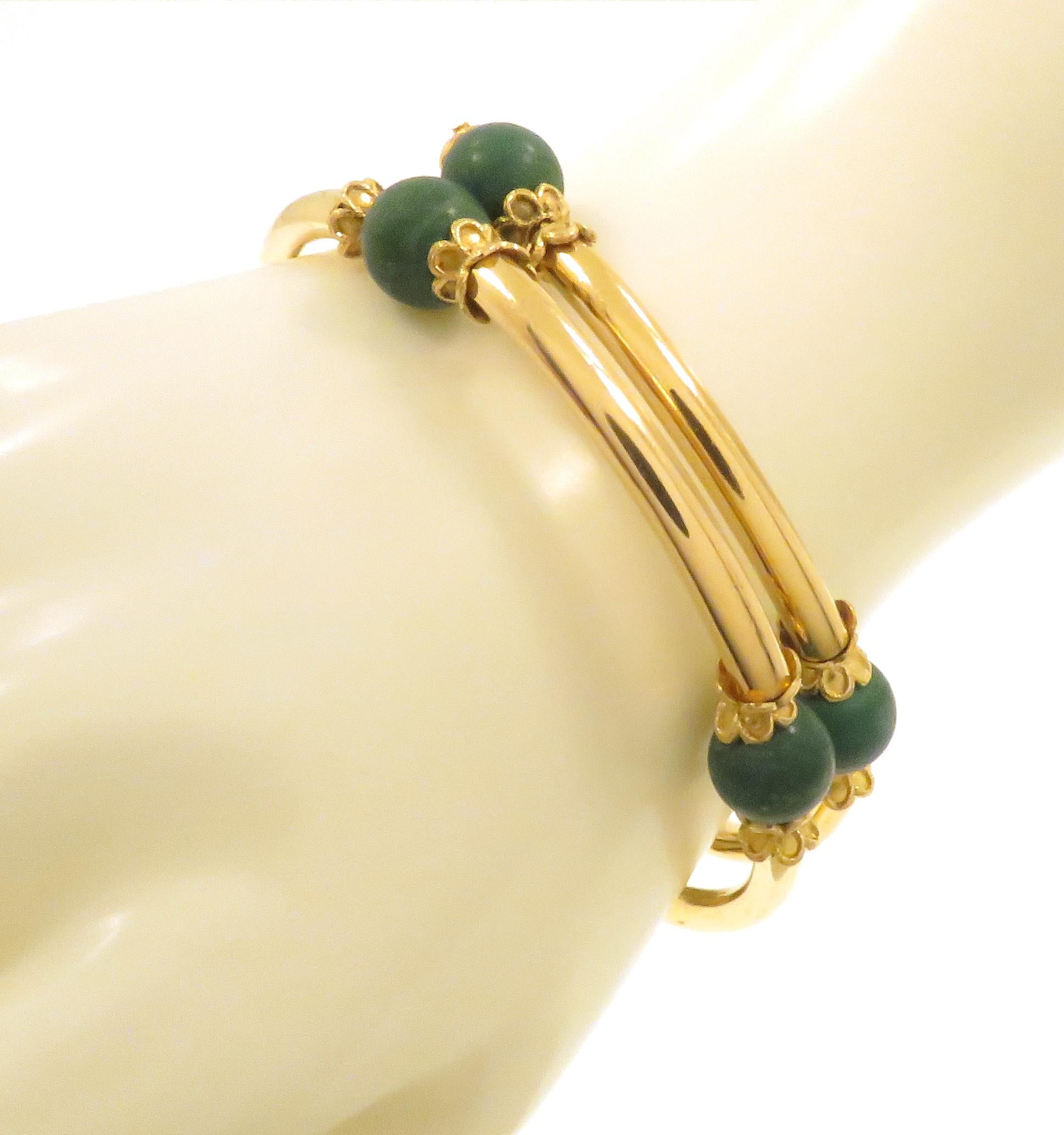 Vintage bracelet in 18k yellow gold with 8 green turquoise beads. The bracelet features a spiral of gold tube elements spaced by turquoise beads. The beads are decorated by petal sharpened little cups. A spring gold wire flows inside the bracelet