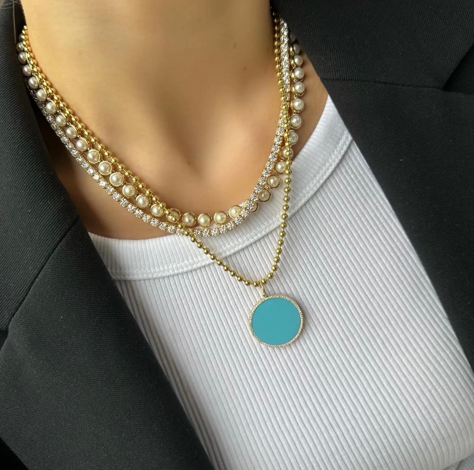 Abbagliante charm a forma di disco in oro giallo 14kt con turchese vibrante.  Questa incantevole gemma è incastonata in una delicata cornice di diamanti scintillanti.  Il risultato è un charm che combina la bellezza rilassante del mare con