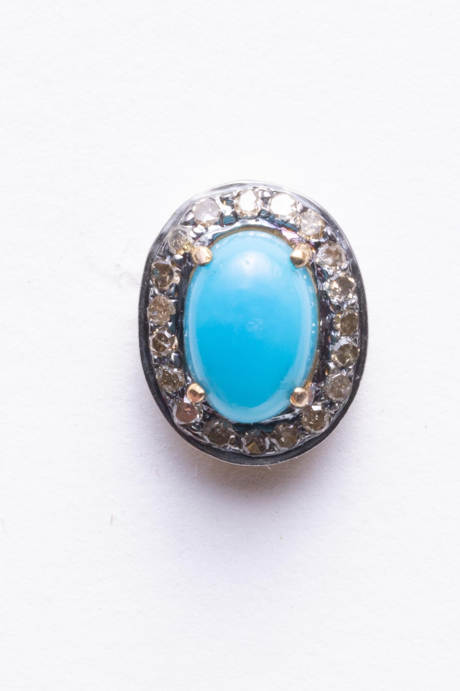 A pair of oval, cabochon Sleeping Beauty Turquoise stud earrings bordered with pave`-set, round brilliant cut diamonds.  Set in sterling silver with 18K gold posts for pierced ears.  Diamonds total .28 carats and turquoise total 1.50 carats.

The