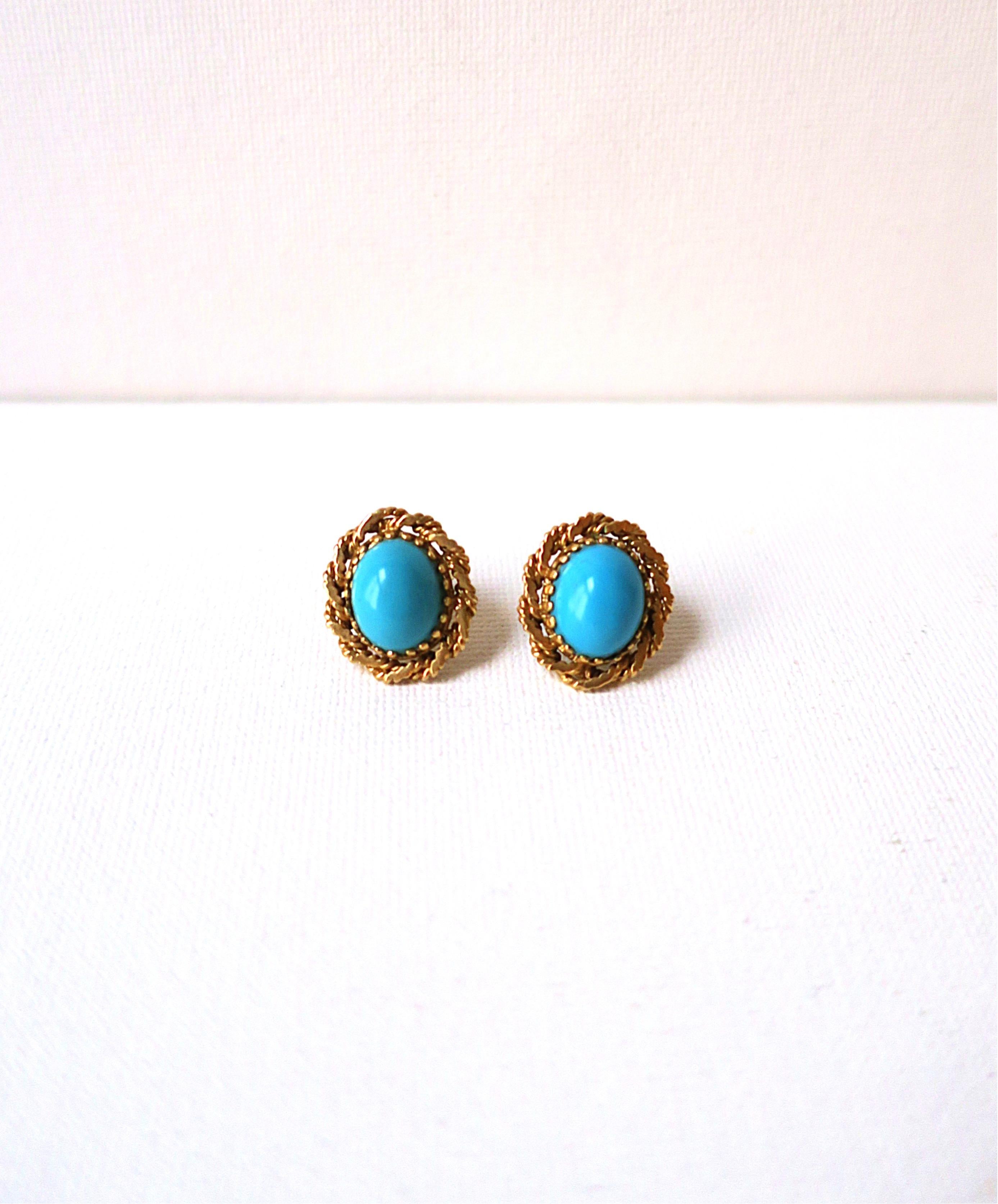 A beautiful pair of turquoise gemstone and yellow gold earrings with rope design, circa mid to late-20th century. Pair have an oval cabochon turquoise gemstone center within 14-karat yellow gold setting, finished with a rope design around. A