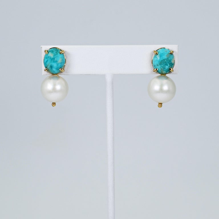 Cabochon-cut Turquoise and round, white 14mm Freshwater Pearl drop 14k yellow gold stud earrings. Stud earrings are 1.13 inches or 30mm in length. Gorgeous Turquoise and Pearl gemstones make these timeless yet contemporary earrings versatile to be