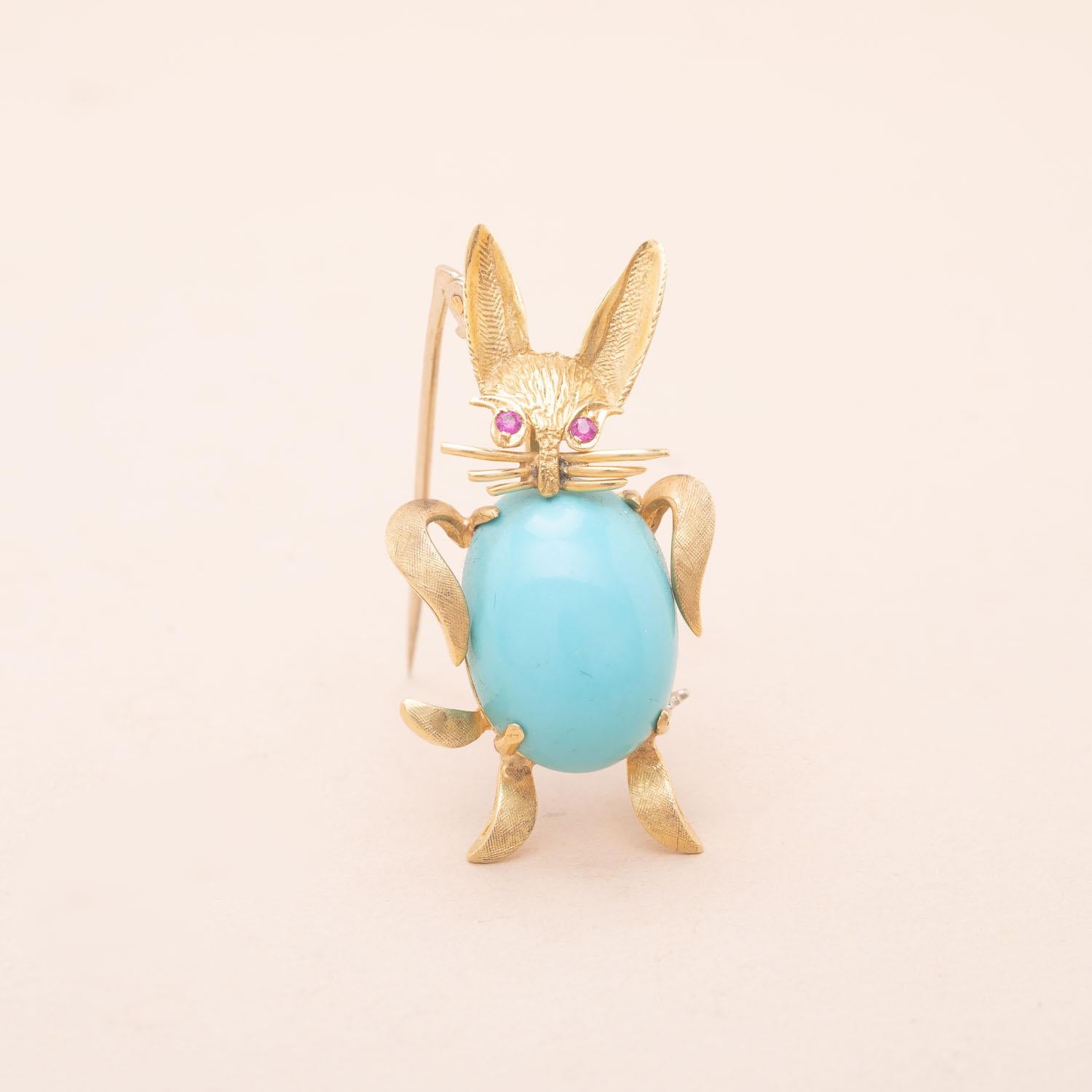 18K Two-toned gold turquoise rabbit brooch. The rabbit's eyes are made of brillant-cut rubies 
Engraved and brushed gold 
Vintage from the seventies, probably greek craftsmanship 
61 AA, owl and 750 hallmarks
Height : 4cm
Gross weight : 6.55g