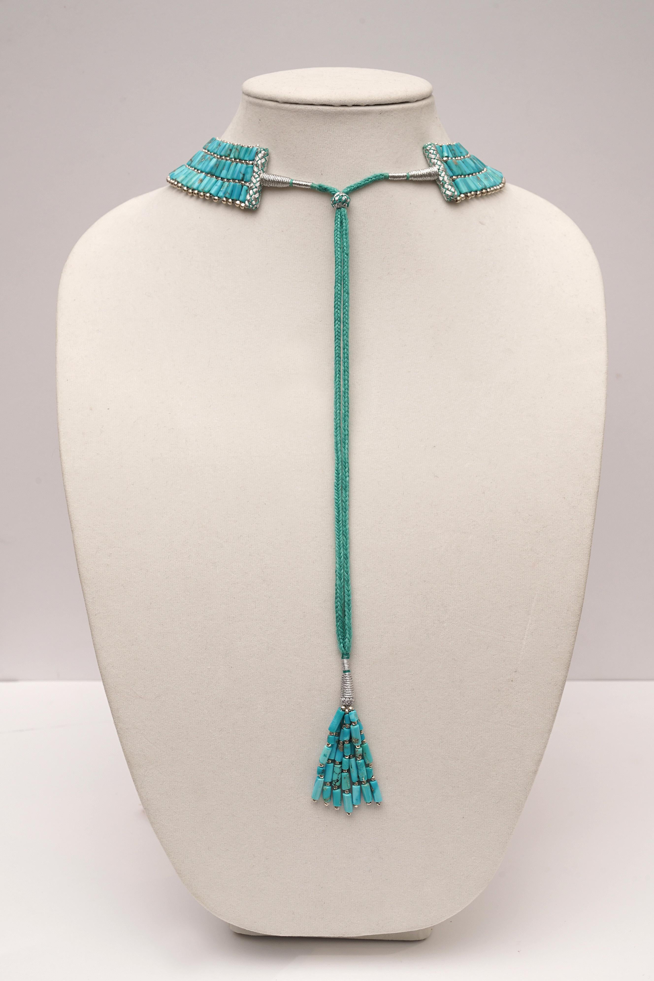Stunning triple-row turquoise collar necklace bordered with sterling silver beads.  Bolero clasp allows the length to be adjustable and a cluster of turquoise drapes down the back.  Wear on an open neckline or inside a button down shirt.  Lovely and