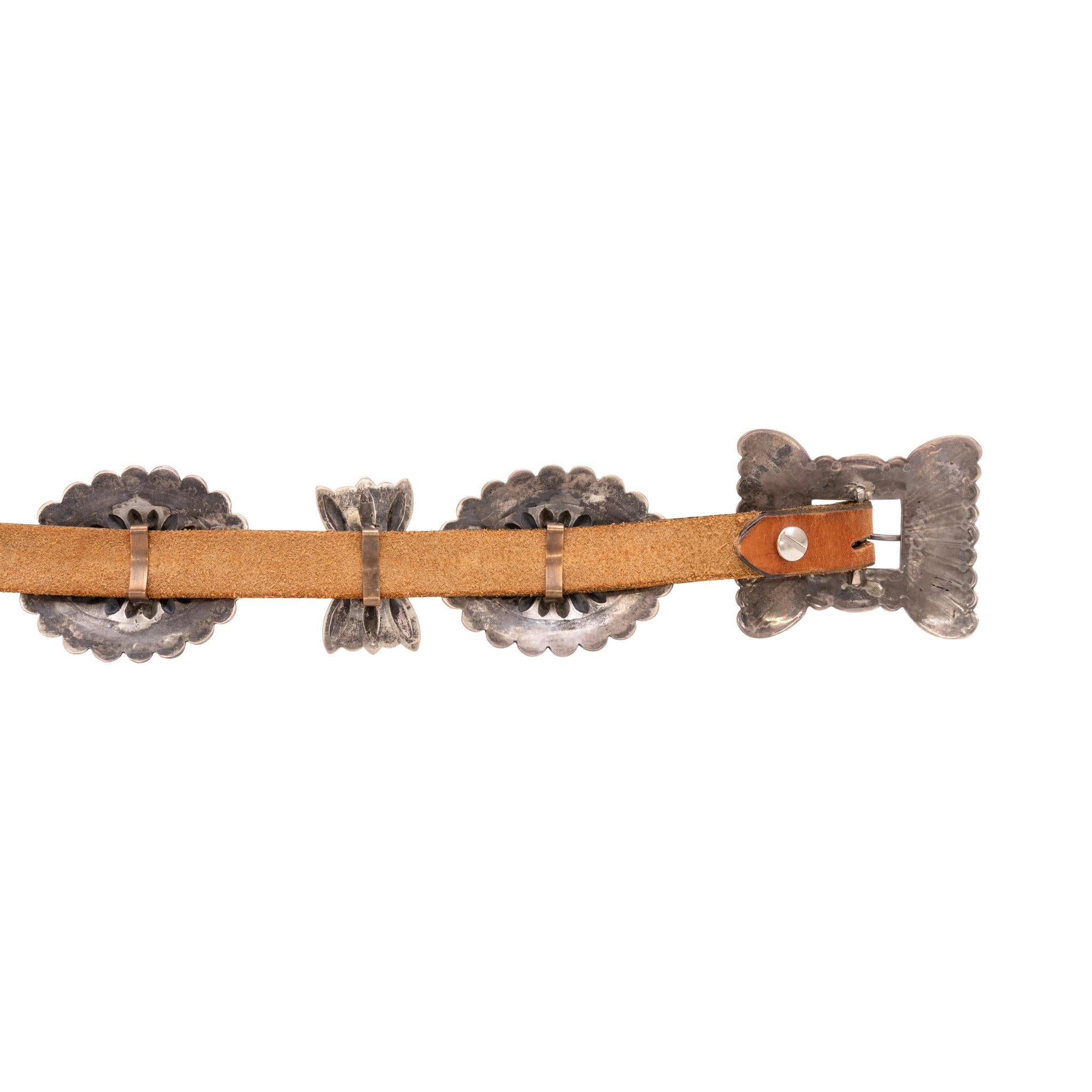 Ceinture concho en turquoise et argent. Conchos ovales et papillons en alternance avec un motif estampé et des bords festonnés. Boucle rectangulaire. La turquoise provient de la mine Kingman en Arizona. 11 conchos au total. Les conchos peuvent être