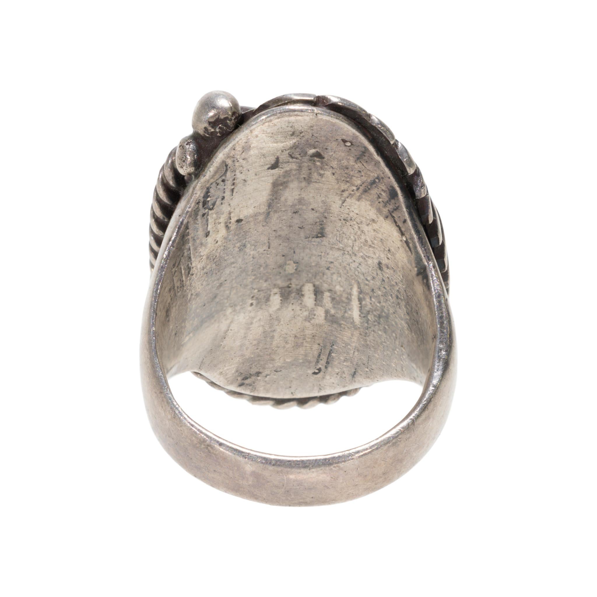 Anello in argento e turchese attribuito a Dan Lewis. Anello a pietra singola, con pietra grande con matrice d'argento e quarzo, circondata da foglie dettagliate, bordo in corda ritorta e dettagli in perline di sterling. Bellissimo pezzo distintivo,