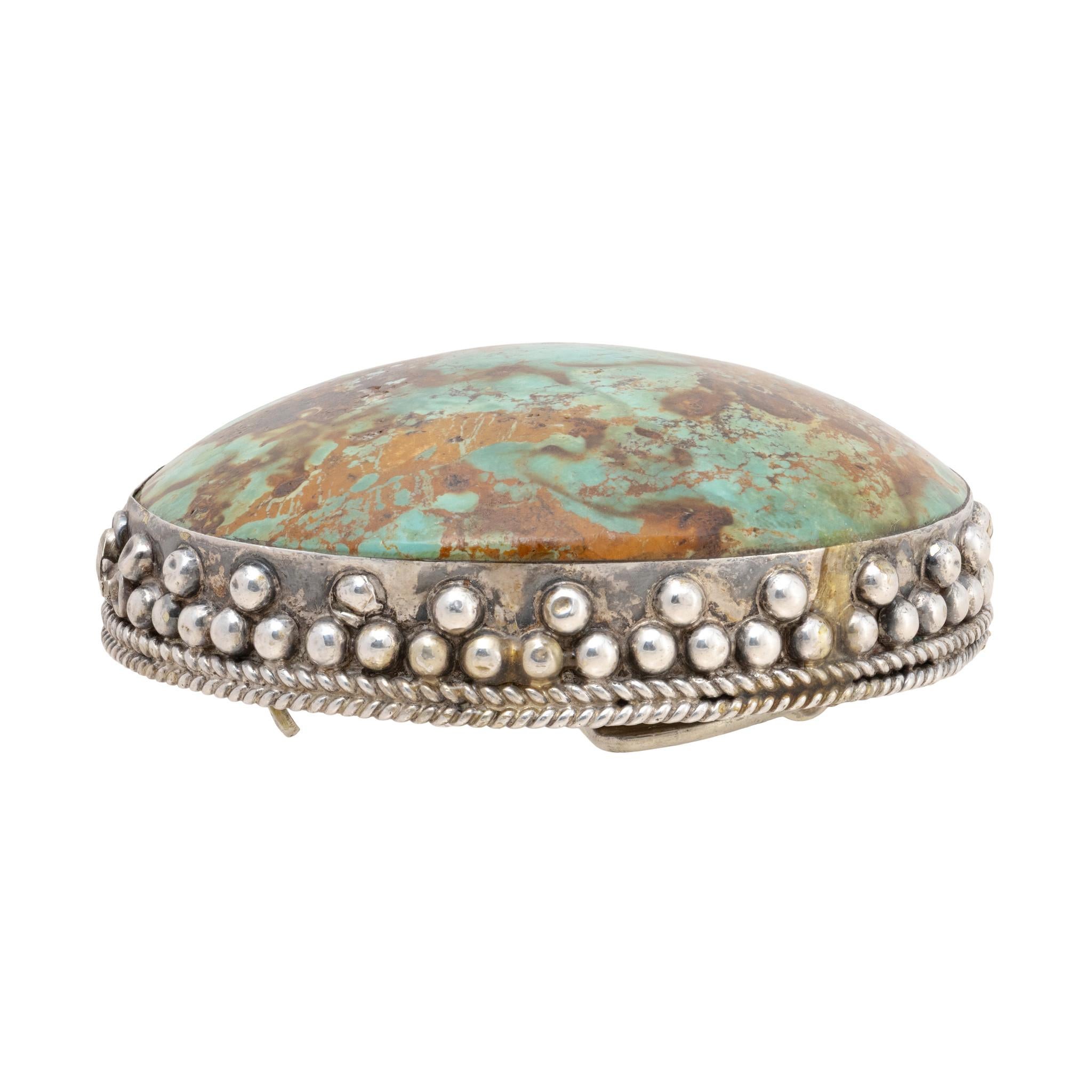 Außergewöhnliche Gürtelschnalle aus einem einzigen Türkisstein. Großer Royston-Türkisstein, eingefasst in eine schlichte Sterling-Bordüre mit Perlen und gedrehten Seildetails. Der Stein ist ein leuchtendes Blaugrün mit goldfarbener und brauner