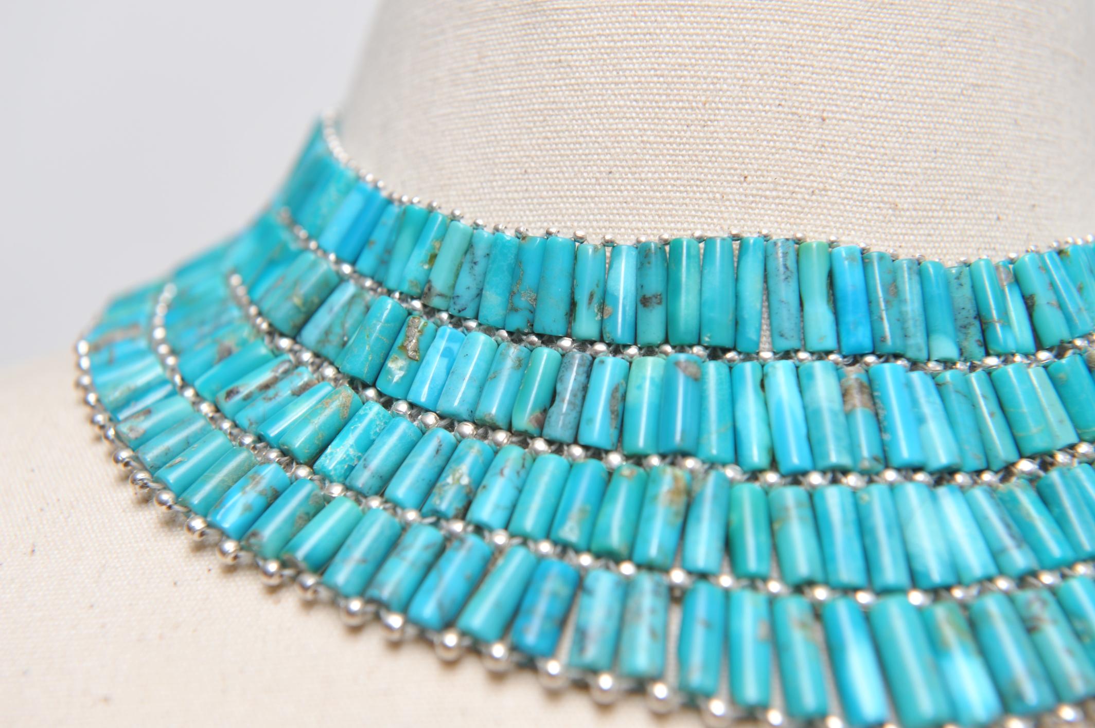 A hand-woven, American turquoise and sterling silver collar necklace.  Has a bolero style closure and a cluster of turquoise hangs down the back...a sexy touch.  Stunning on an open necklace or just inside a button down.  Very versatile.  This