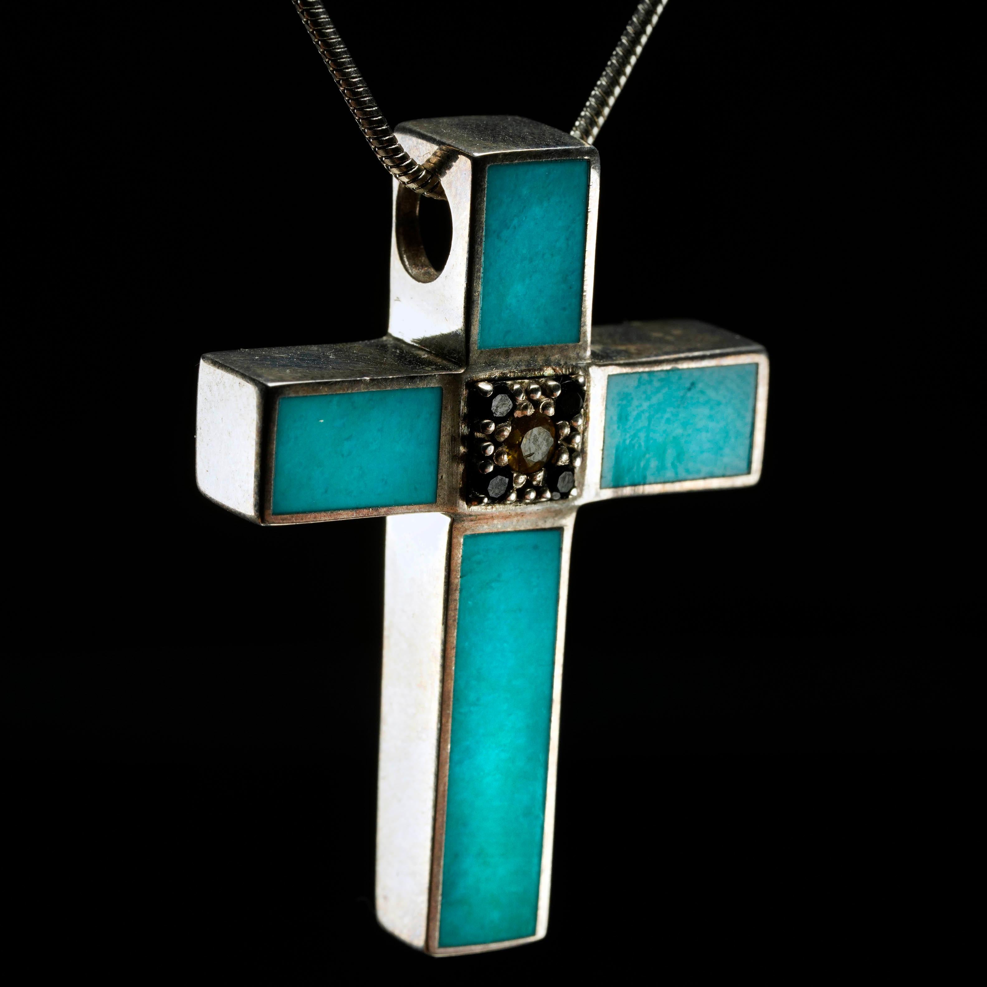 Questo sorprendente ciondolo a forma di croce è un'accattivante fusione di colori vivaci ed elegante maestria. Questo ciondolo, incastonato minimamente nell'argento sterling, presenta cinque pezzi di turchese blu cielo intensamente pigmentati e