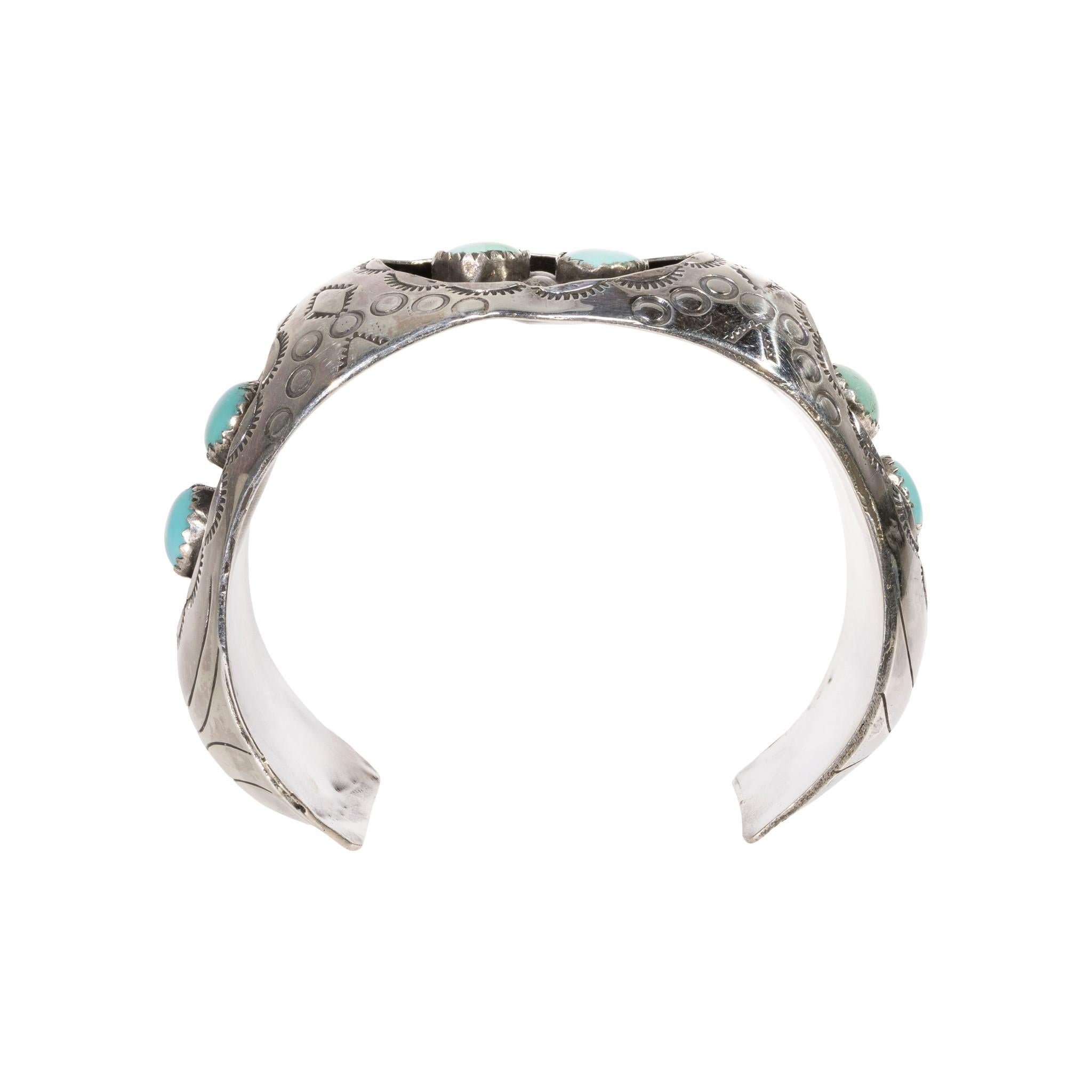 Bracciale in turchese e argento sterling. Sei pietre di turchese Indian Mountain disposte in tre gruppi di doppi grappoli, ognuno dei quali è incastonato in una scatola d'ombra con perline in argento. Le pietre sono di colore verde chiaro con