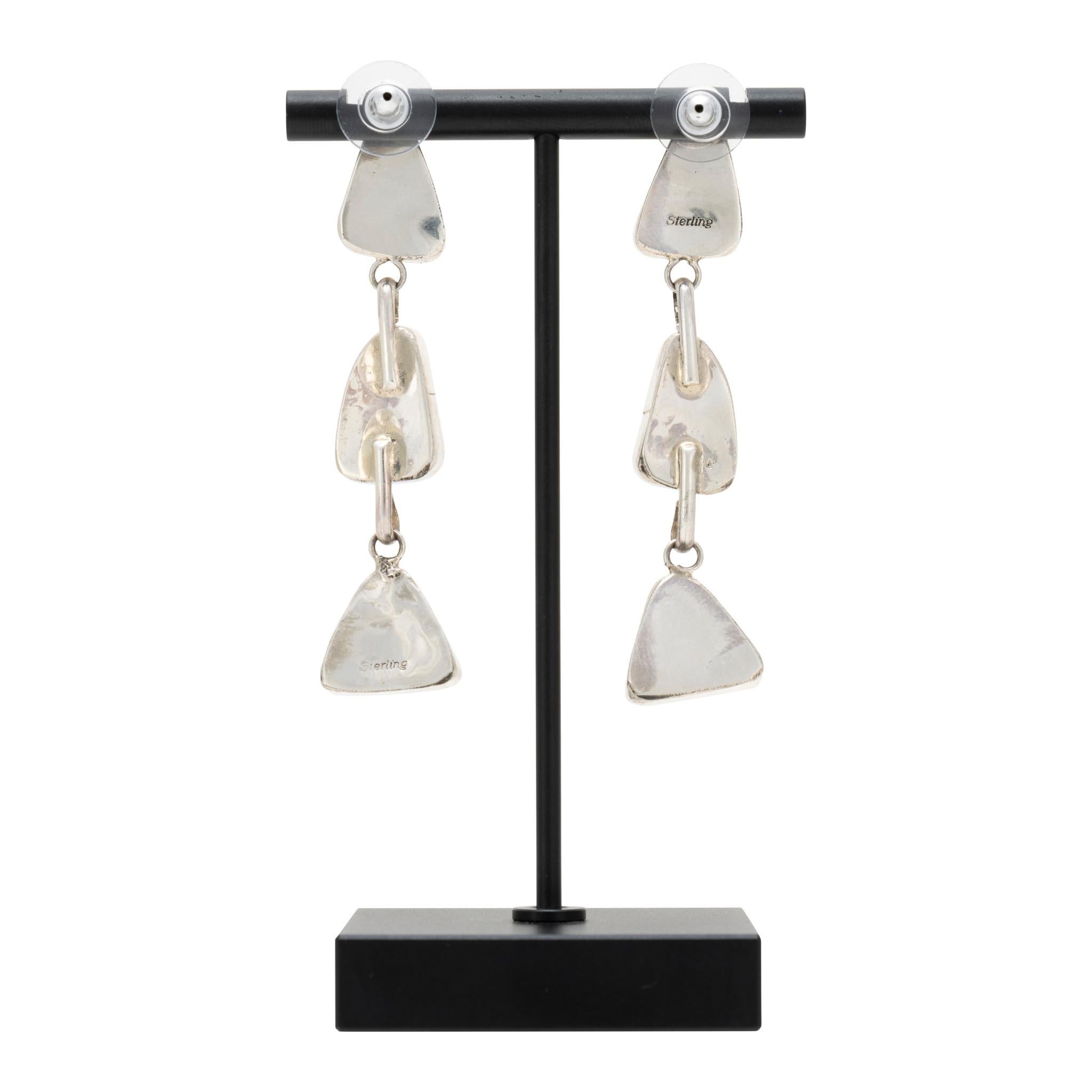 Coppia di orecchini pendenti in turchese Paiute e argento sterling. Tre pietre con incastonatura a dente di sega, fissate l'una all'altra con delle maglie. Post indietro. Le pietre superiori e inferiori sono a forma di triangolo arrotondato, la