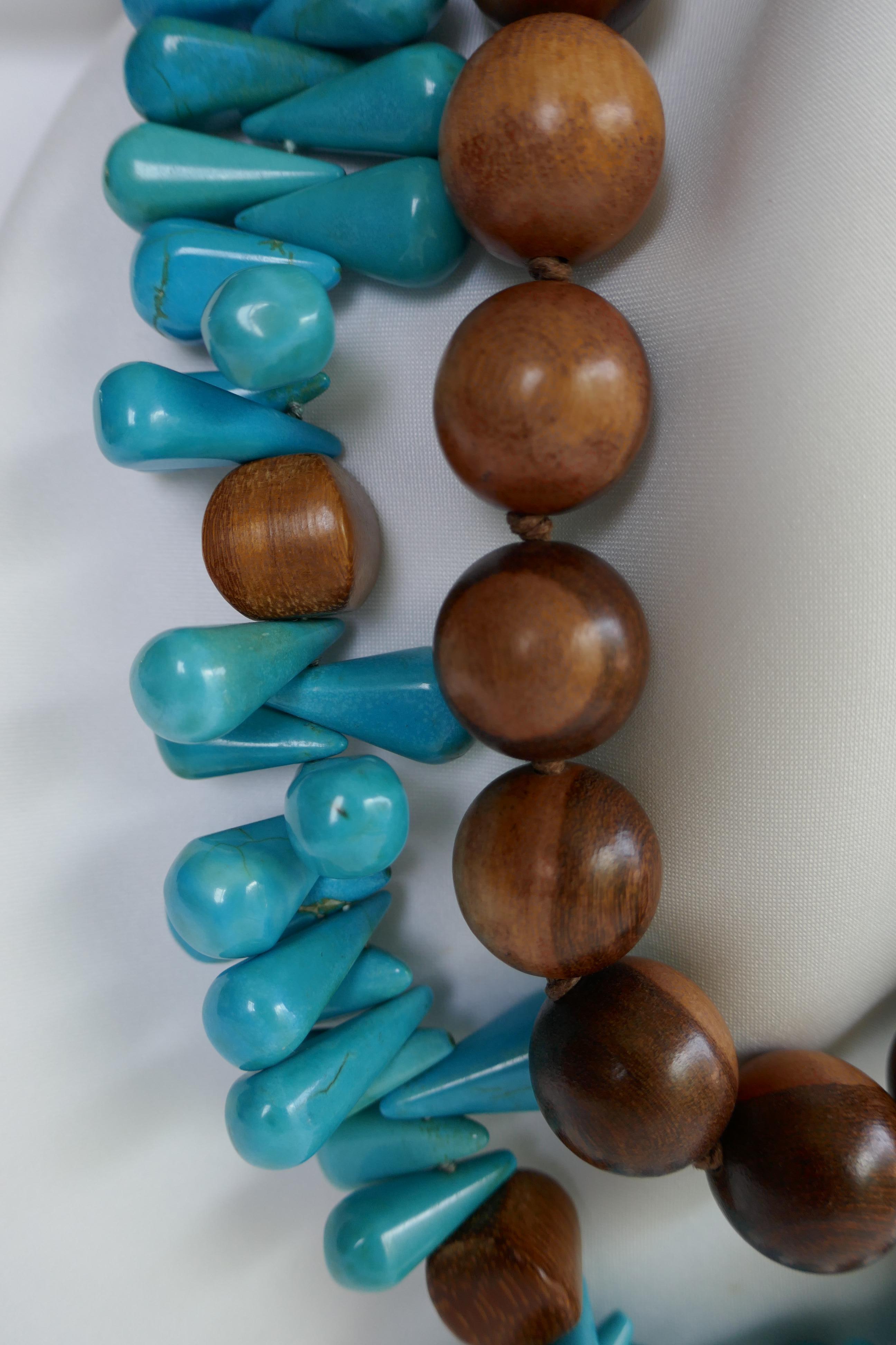 These are two necklace that may be worn together of separately. Worn together they make a stunning statement necklace. The wood beads are 20mm and the necklace is 20 1/2 inches long. The reconstituted turquoise* drop bead and wood necklace is 24