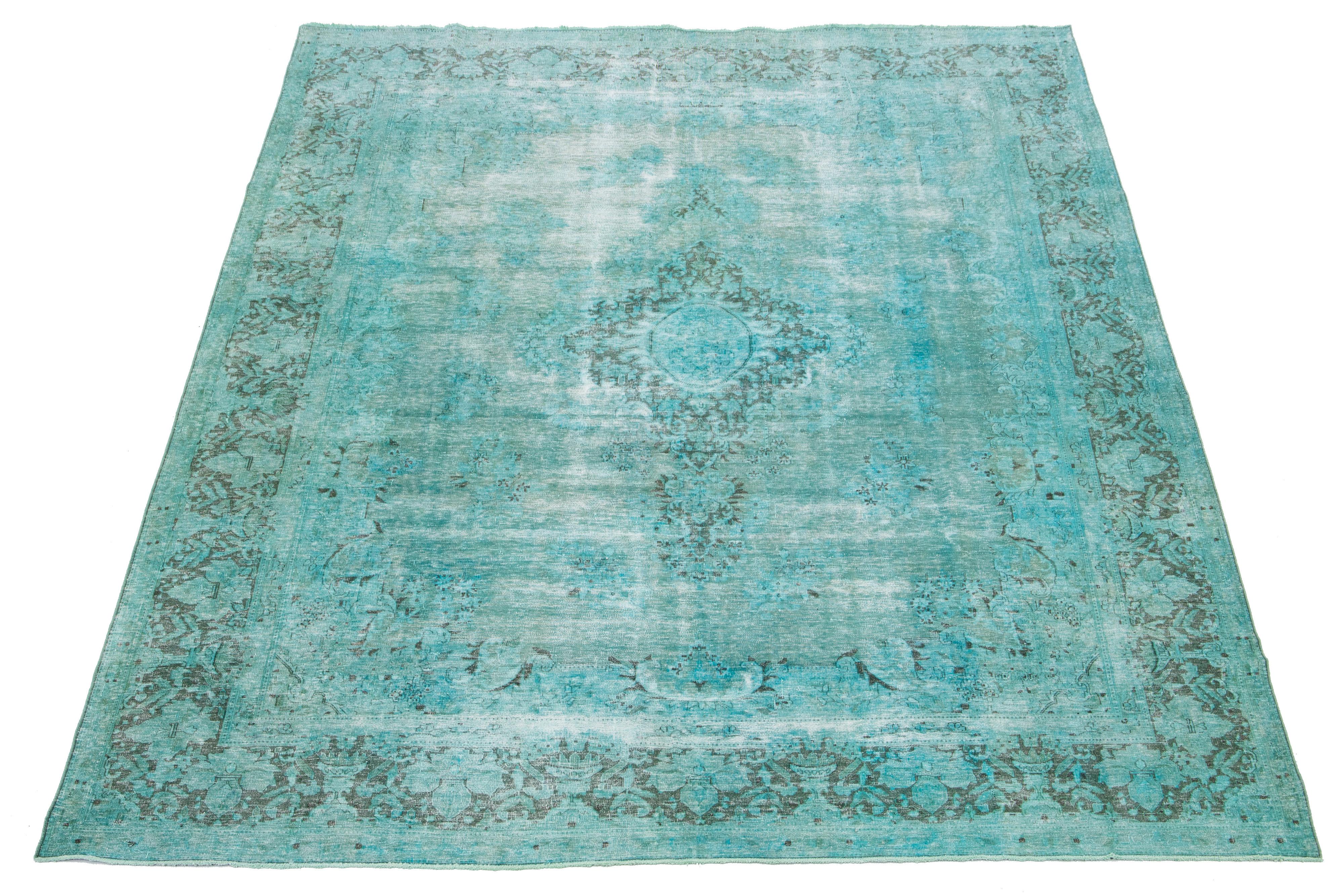 This is an antique hand-knotted wool Persian rug with a Turquoise color field. It features a medallion floral design with gray accents.

This rug measures 9'6'' x 12'10