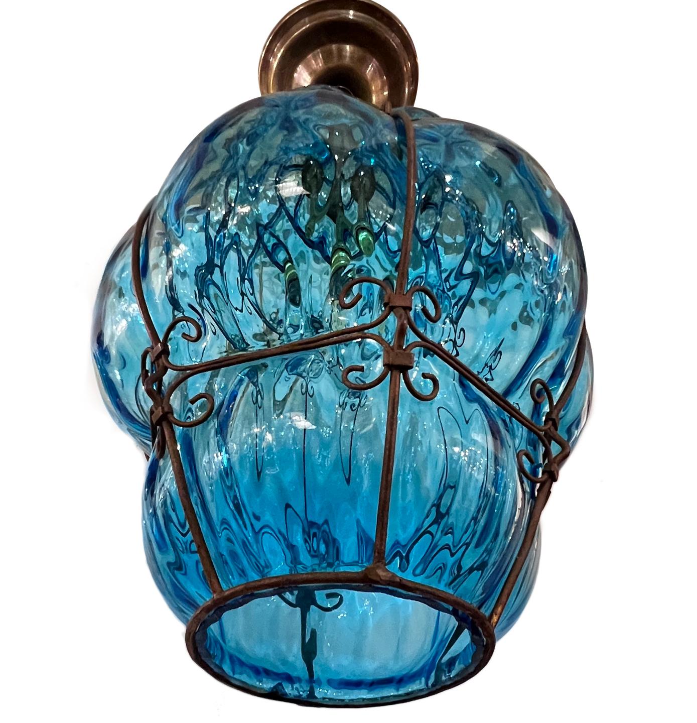 A circa 1930’s blown turquoise colored Murano glass lantern with iron-work frame and one Edison interior light.

Measurements:
Height of body:16
