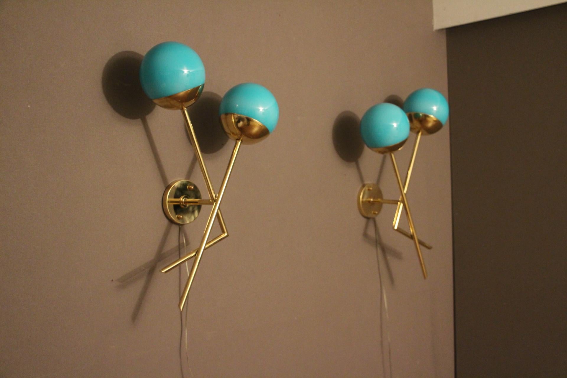This pair of sconces features brass structure and 2 turquoise blue Murano glass globes. It is very simple and very elegant at the same time.
It could be showcased in every distinctive interiors.
When the light is on, the globes are light blue and