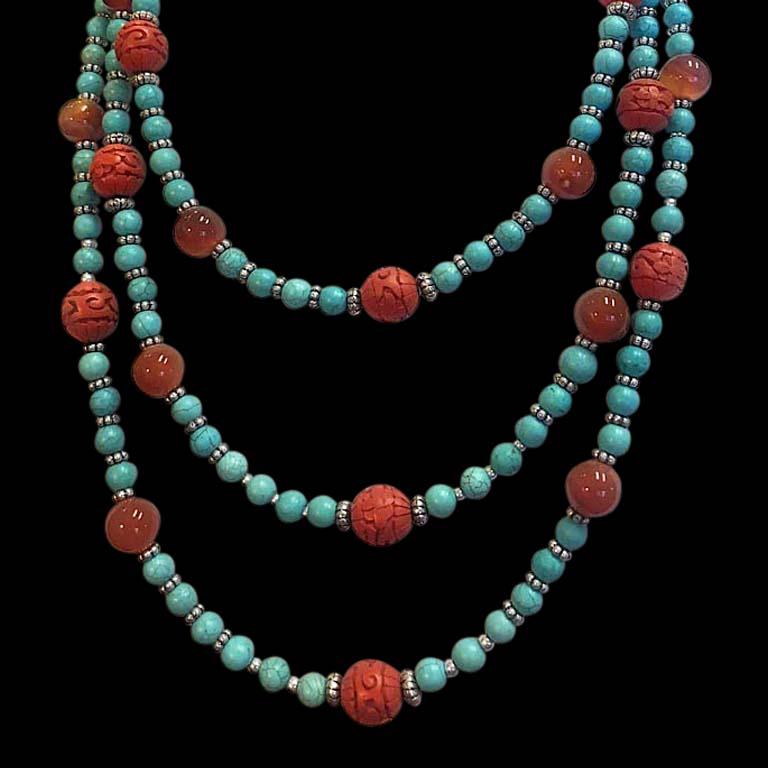 This triple strand necklace of peacock blue turquoise, carnelian, and bright red Chinese carved cinnabar beads with silver spacers is my own design. With matching bracelet and earrings, it makes a colorful jewelry suite. The earrings have sterling