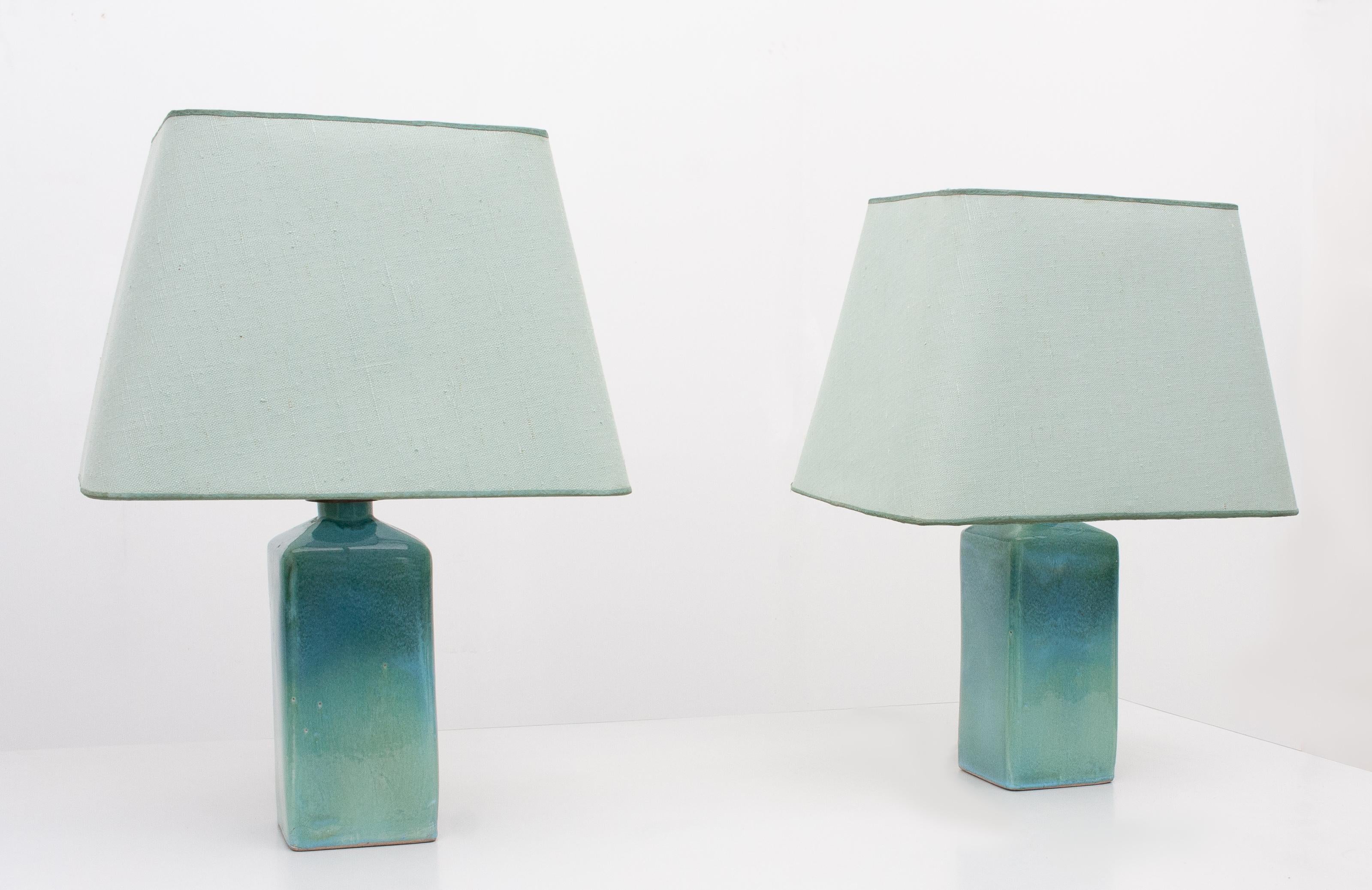 Very nice Turquoise color lamp stands. Square shape. Comes with matching shades.
Signed. 1970s. Measures: Without shades. Height 30 cm, width 10 cm, depth 10 cm. one E27 bulb.
With shades height 49 cm, width 35 cm, depth 24 cm.
   