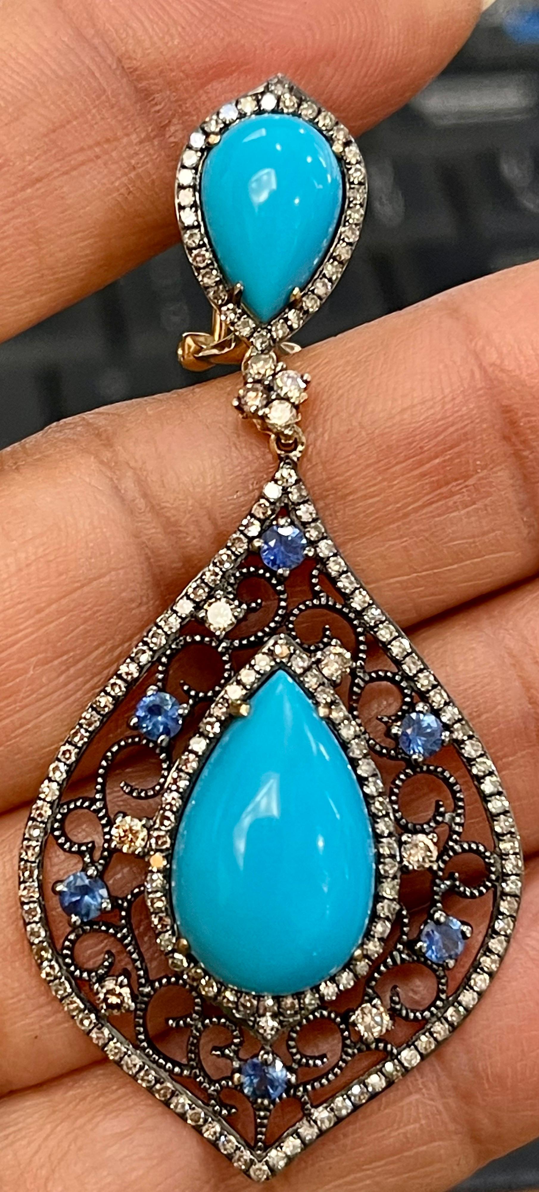 Turquoise, Champagne Diamond & Sapphire Dangling Earring In 14 Karat Yellow Gold
Each  Pear shape turquoise about 3.5  to 4 carat in the drop and approximately 2.5 ct in the stud part of the earrings.
Very desirable color and quality.
perfect pair