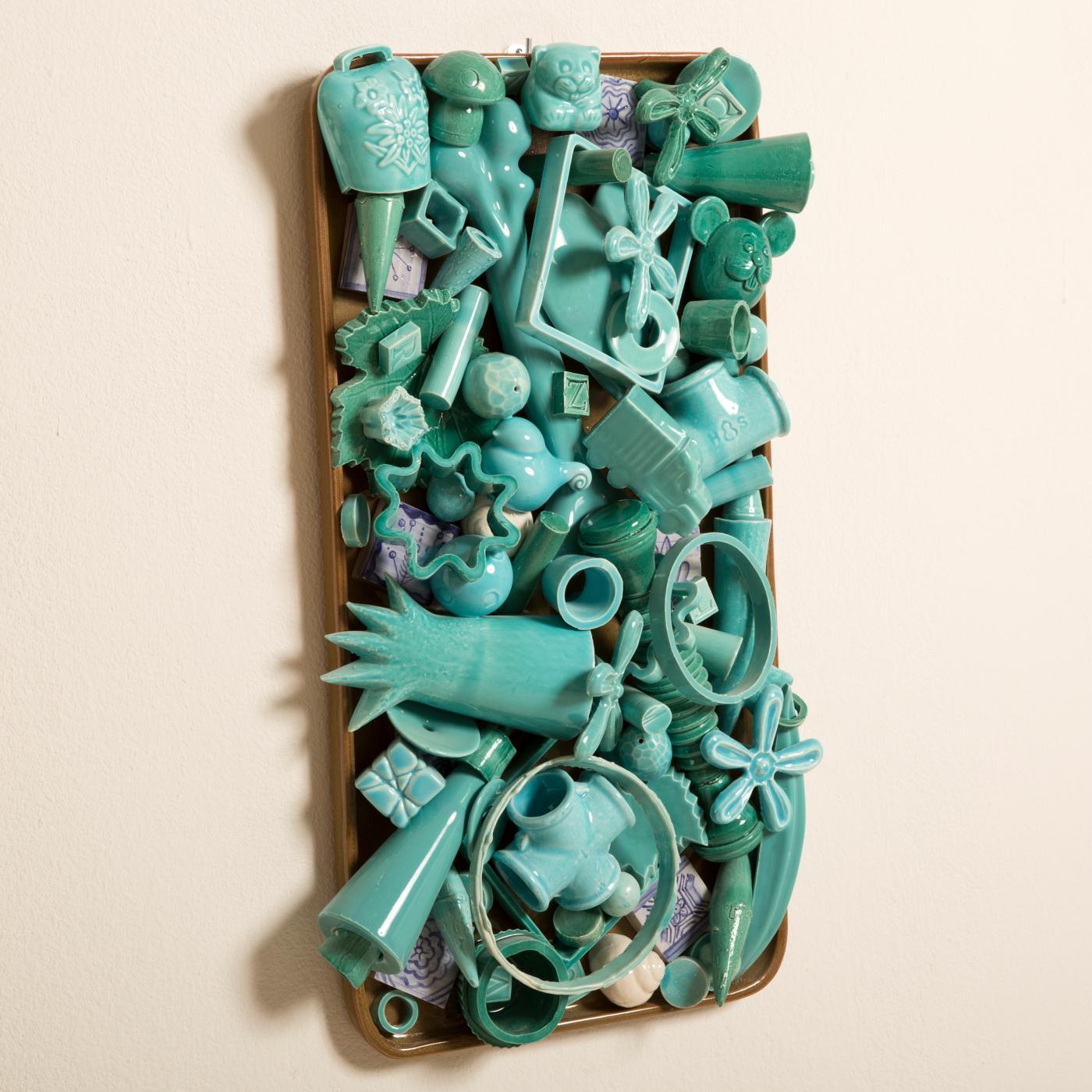 An array of ceramic accoutrements depicts a microcosm of life. Handcrafted flawlessly, this turquoise wall sculpture is a great example of the 