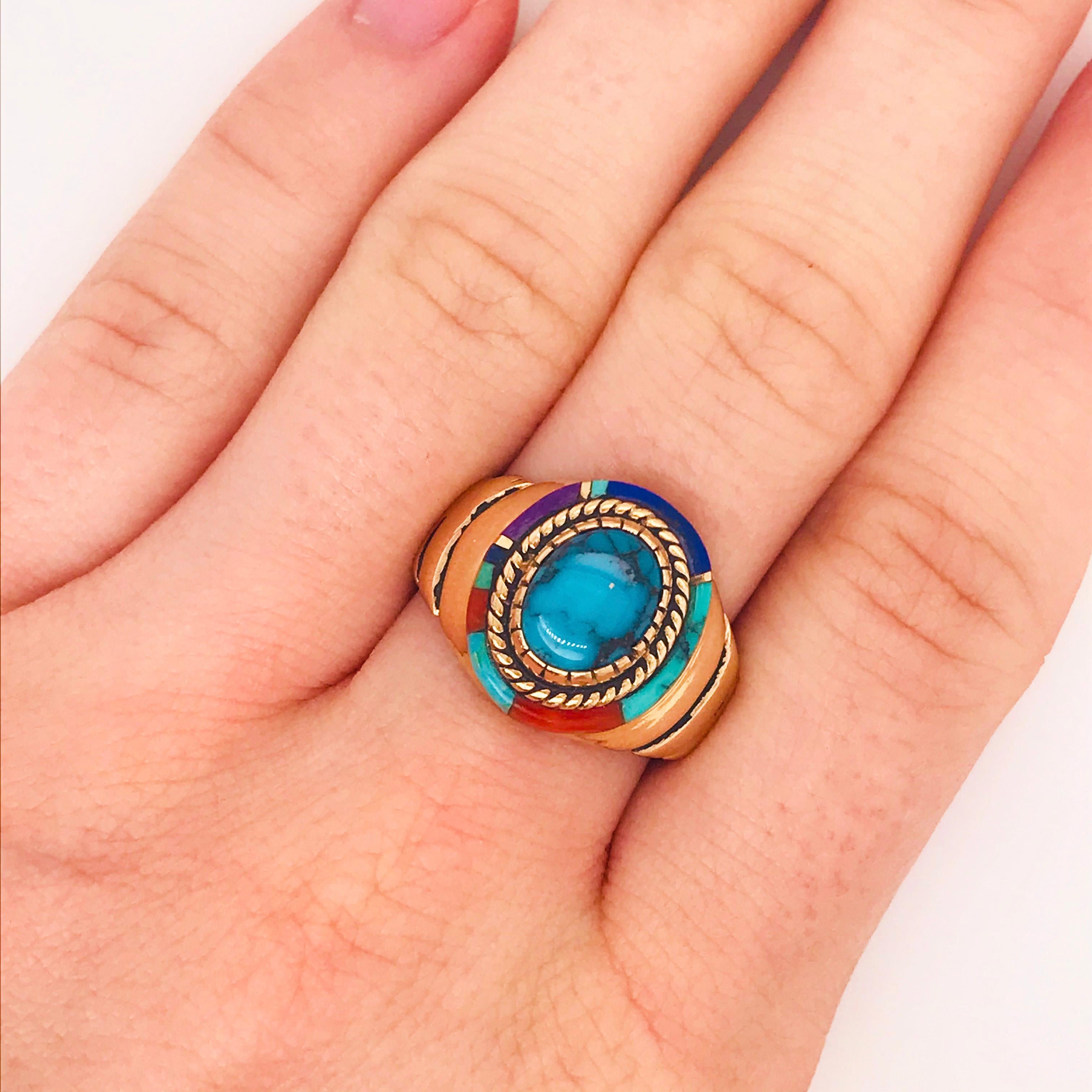 This one of a kind ring has the most unique design! This is a bold fashion ring that has been hand crafted with beautiful natural gemstones. In the center is an oval piece of gorgeous genuine turquoise that is set in a textured bezel setting.