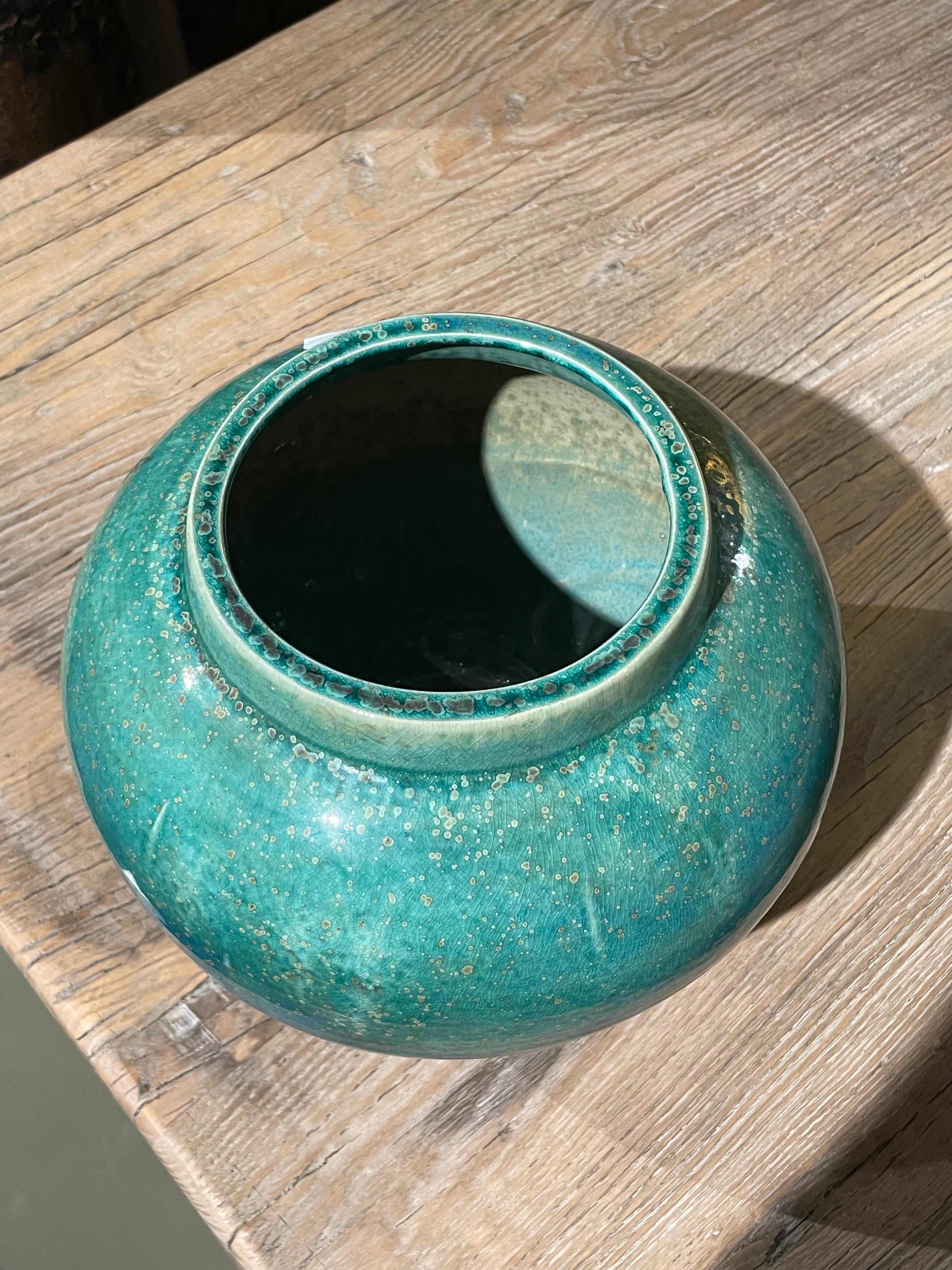 Contemporary Chinese mottled turquoise coloring with crackle glaze vase.
Classic simple shaped pot.
From a large collection of different sizes and shapes.

