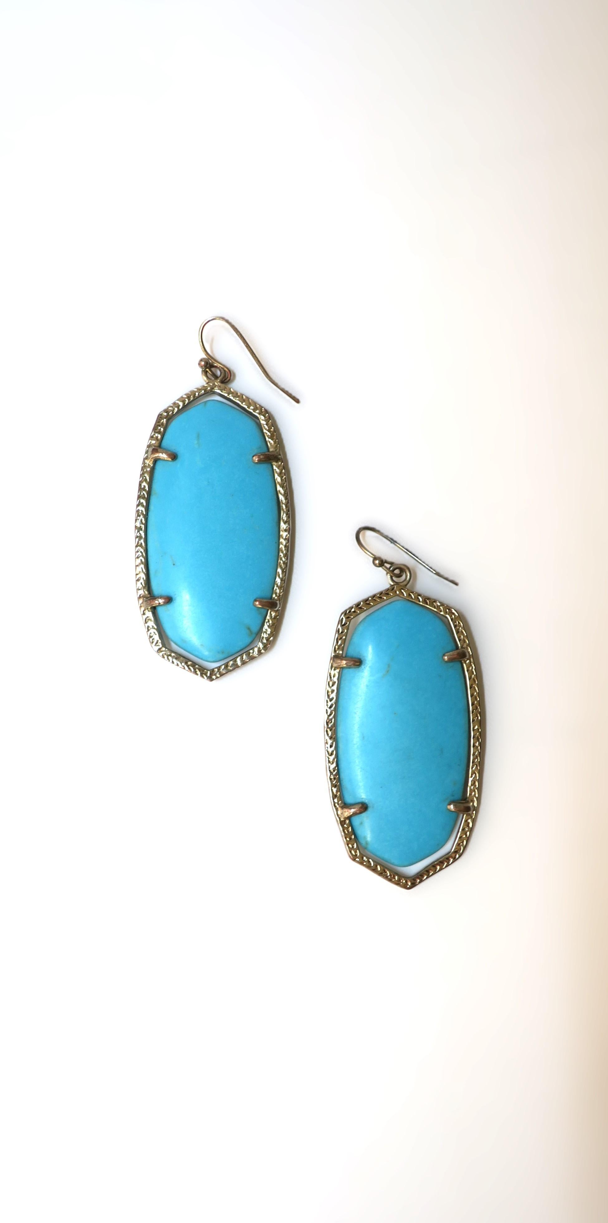 A pair of turquoise stone drop earrings embraced by silver metal frames with are rhodium plated on brass with natural turquoise stone. Very good condition as shown in images. Dimensions: 1