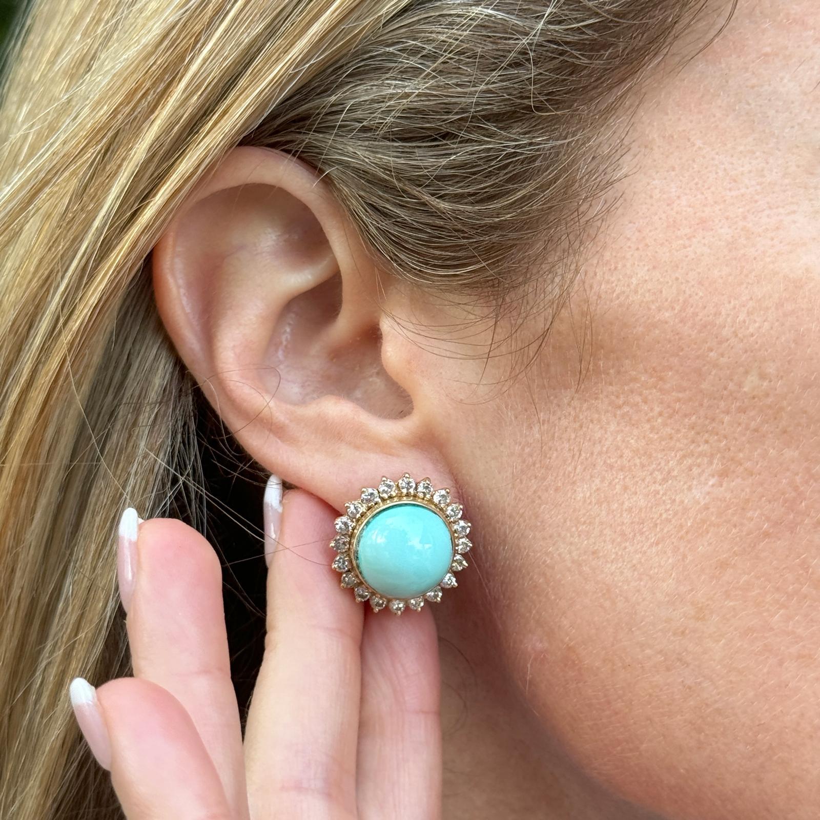 Turquoise diamond earrings crafted in 14 karat yellow gold. The earrings feature two cabochon turquoise gemstones surrounded by 40 round brilliant cut diamonds weighing approximately 2.00 carat total weight. The diamonds are graded G-H color and SI