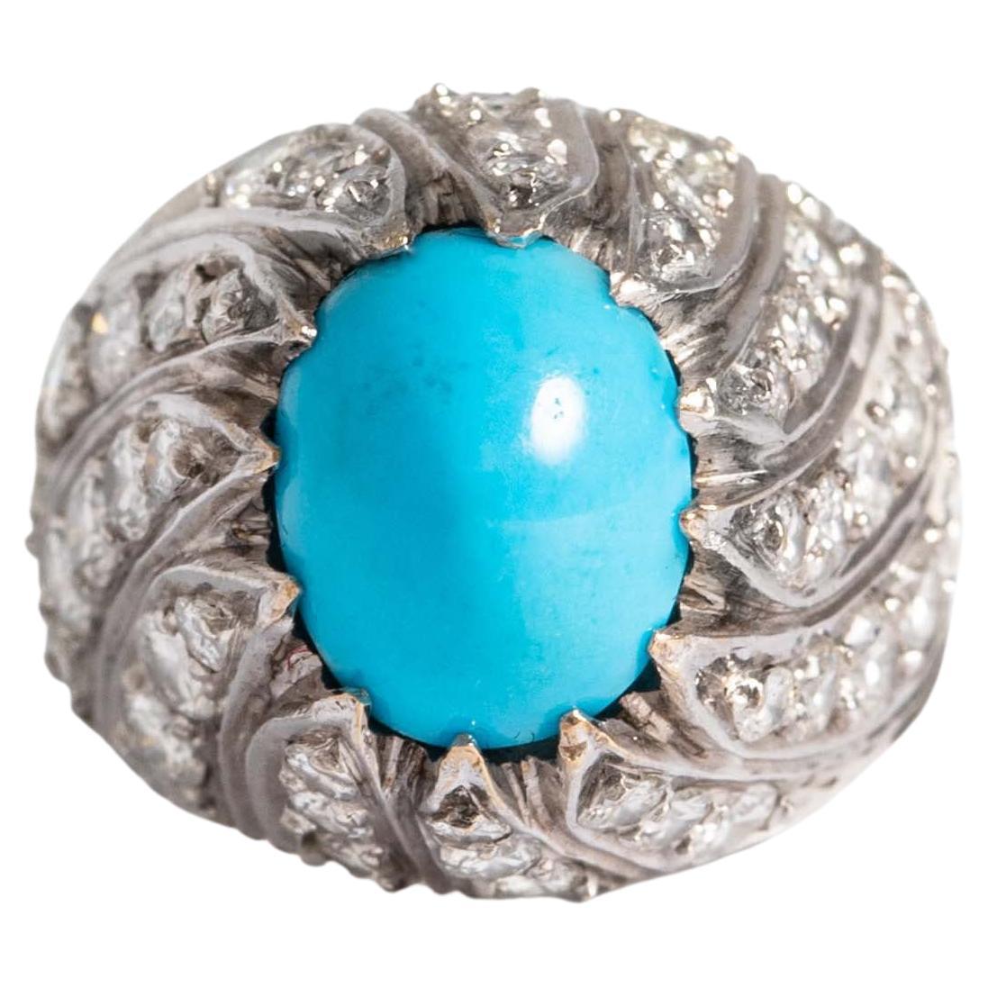 Bague en or blanc 18 carats sertie de diamants de taille ronde et centrée d'une turquoise taillée en cabochon (non testée).
Poids brut : 6,57 grammes.
