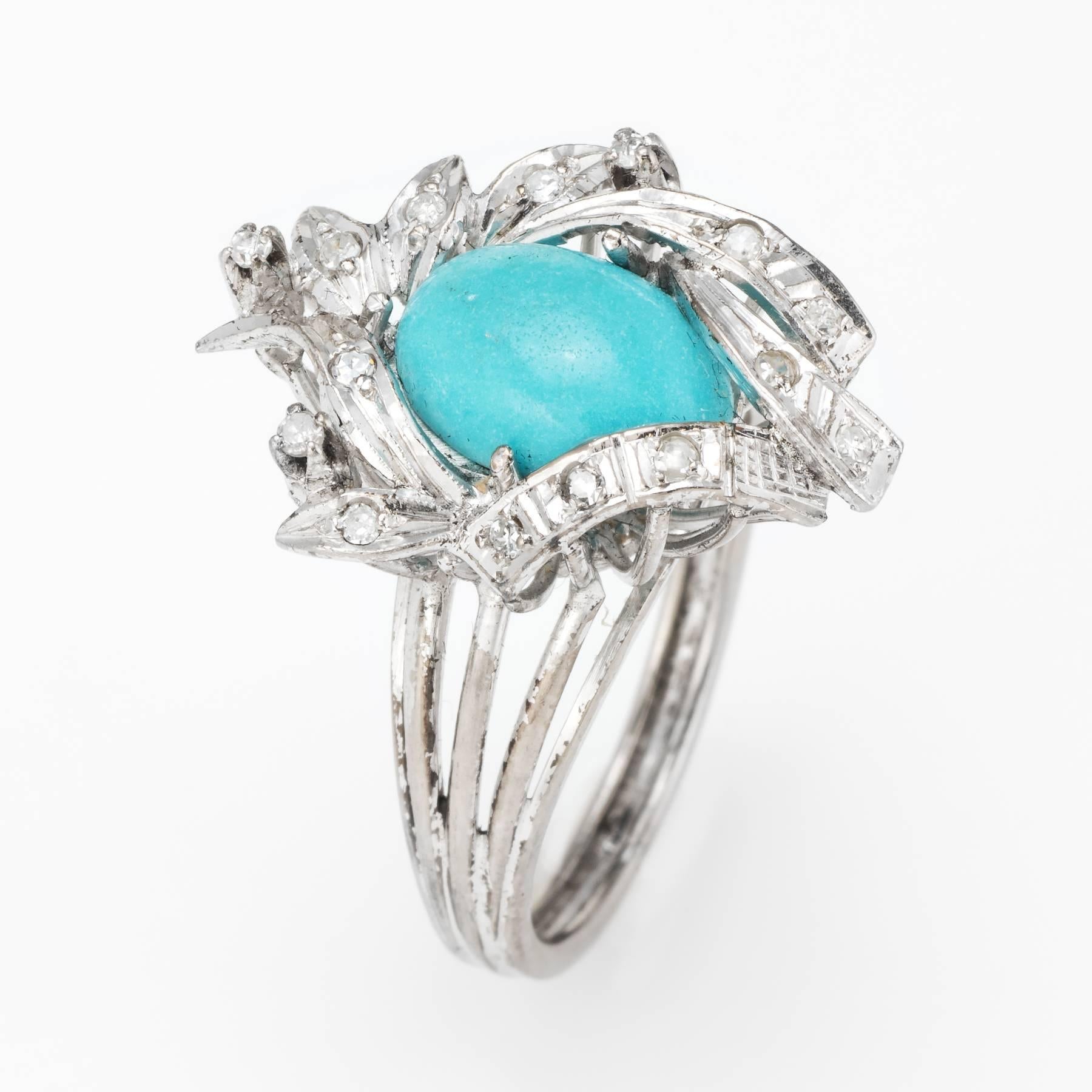 Elegant vintage cocktail ring (circa 1940s), crafted in palladium. 

Centrally mounted cabochon cut turquoise measures 11mm x 8mm (estimated at 3 carats), accented with an estimated 0.15 carats of single cut diamonds (estimated at H-I color and