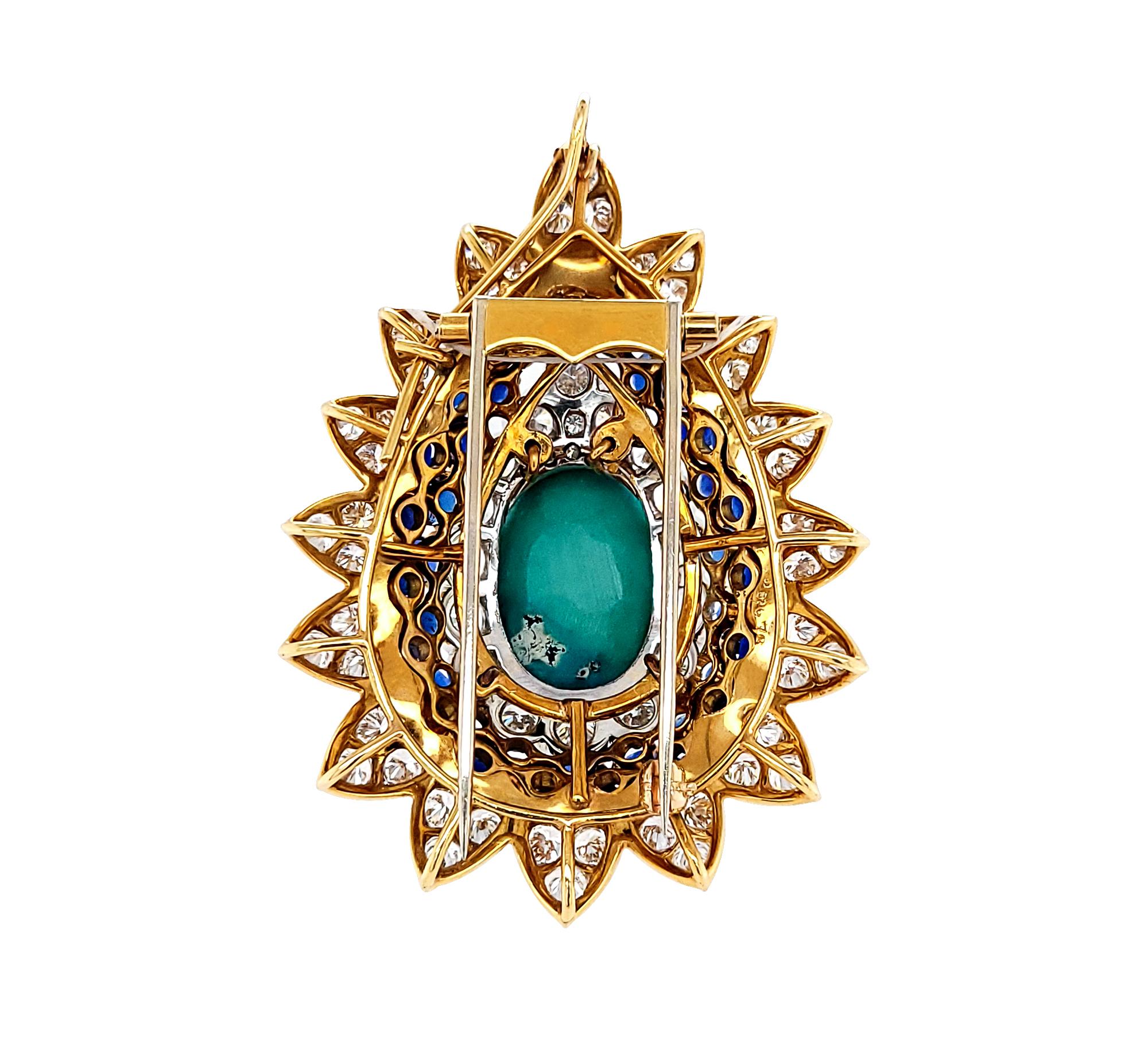 An amazing brooch comprising of a turquoise, diamonds, and sapphires.
Set with a cabochon turquoise center surrounded by a row of round sapphires and a row of round diamonds. 
Can be worn as a brooch or as a necklace pendant. 
The metal is 18k