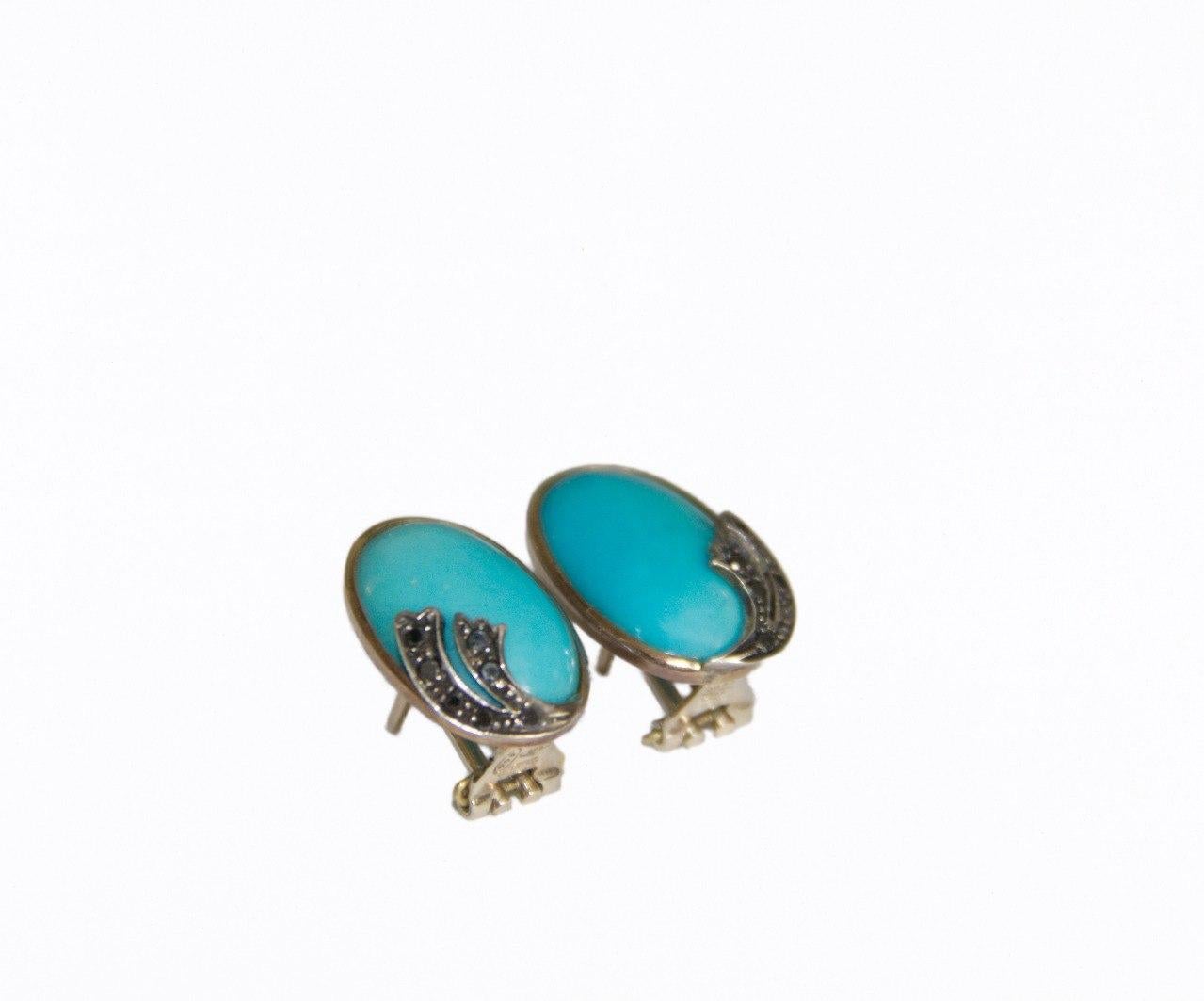 Exquisitely handcrafted, this stunning earring is a testament to timeless elegance and artisanal mastery. Made from 14-karat yellow gold, it features a captivating oval-cut turquoise at its heart, radiating a vibrant yet serene hue that echoes the