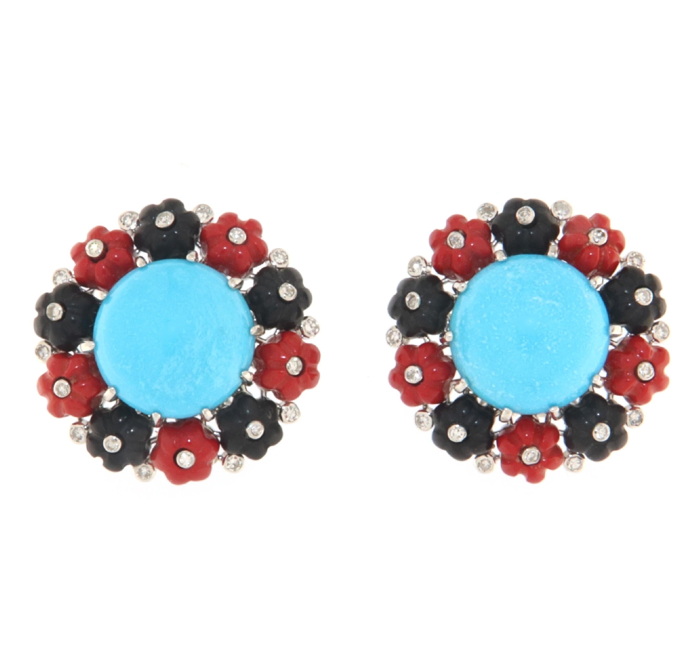 These earrings in 18-karat white gold offer a vibrant expression of color and design, combining Arizona turquoise, diamonds, black onyx, and red coral in a rich and striking aesthetic composition. This mix of gems and materials creates a wearable