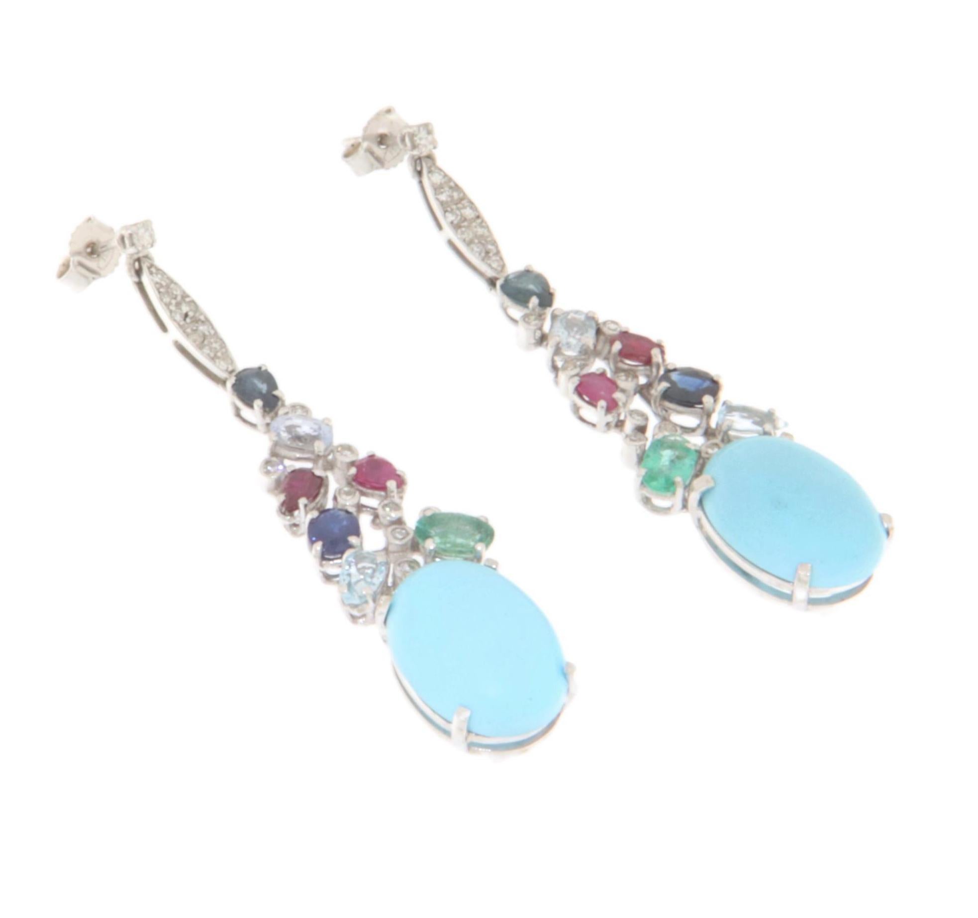 Stunning 18-karat white gold dangling earrings, a masterpiece of elegance and refinement perfect for those looking to add a touch of luxury to their look. Each earring is adorned with a captivating combination of precious stones, carefully selected